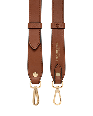 A pair of brown leather straps with gold hardware