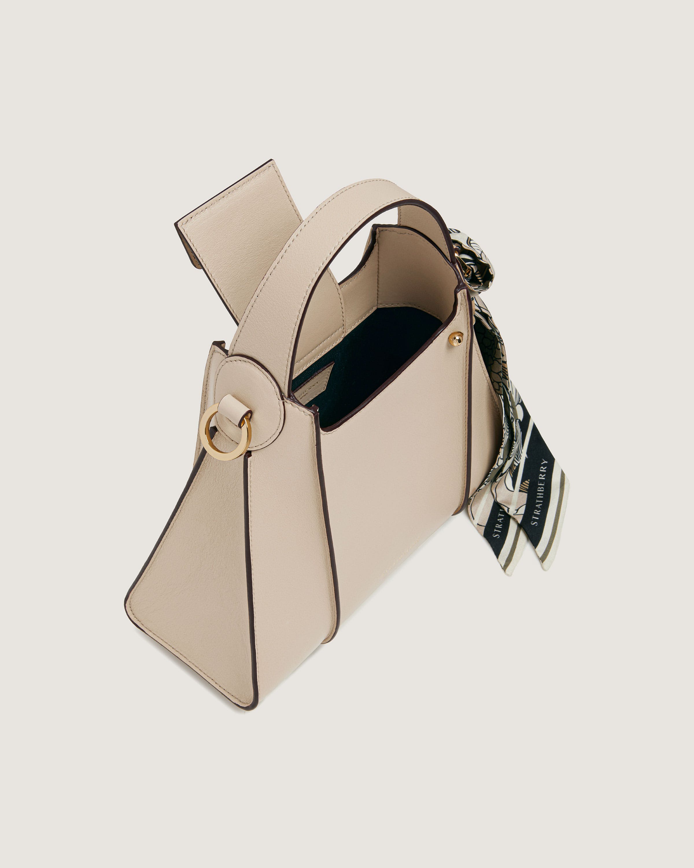 A white purse with a black and gold handle