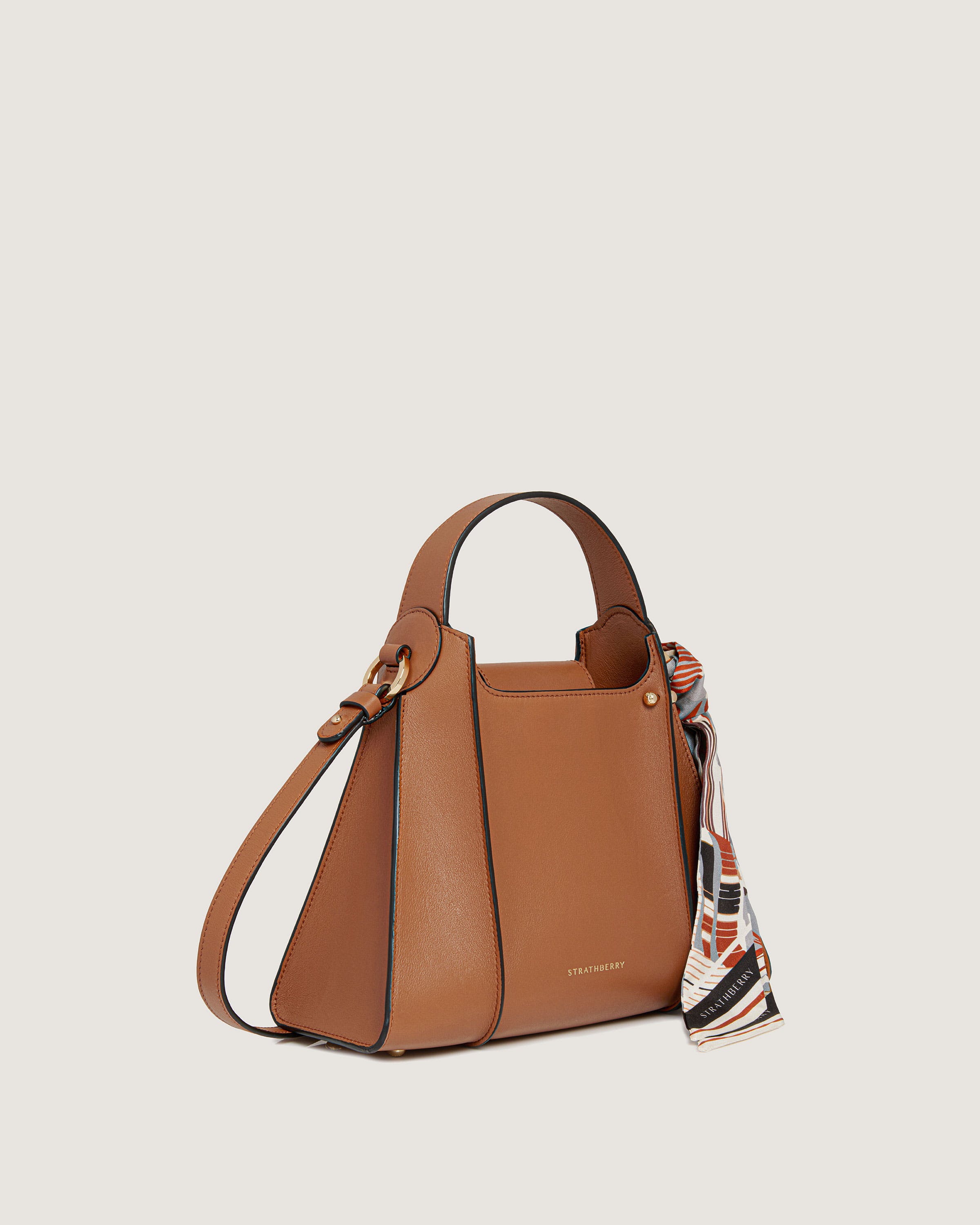 A brown handbag with a scarf hanging from it