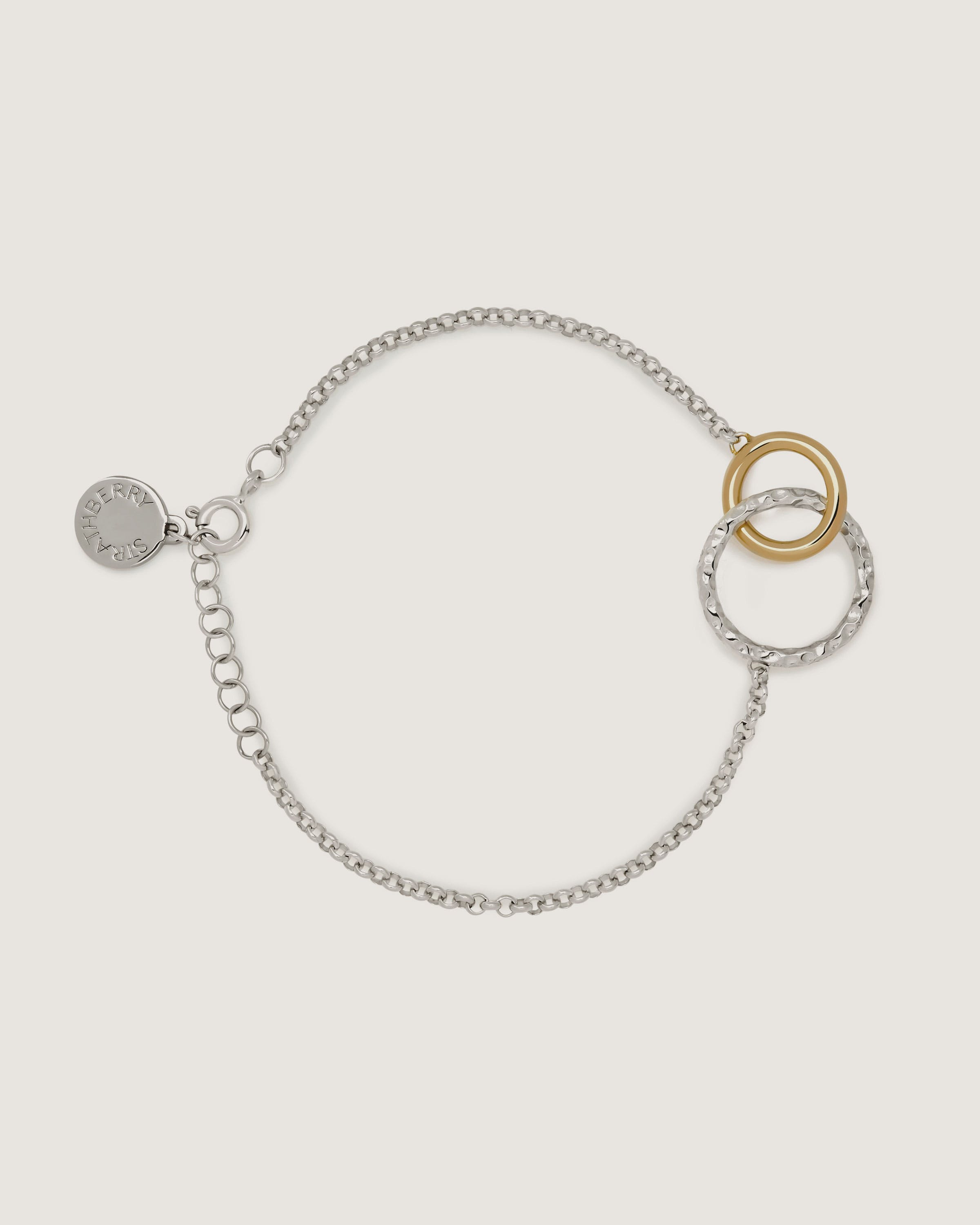 A silver and gold bracelet with two circles