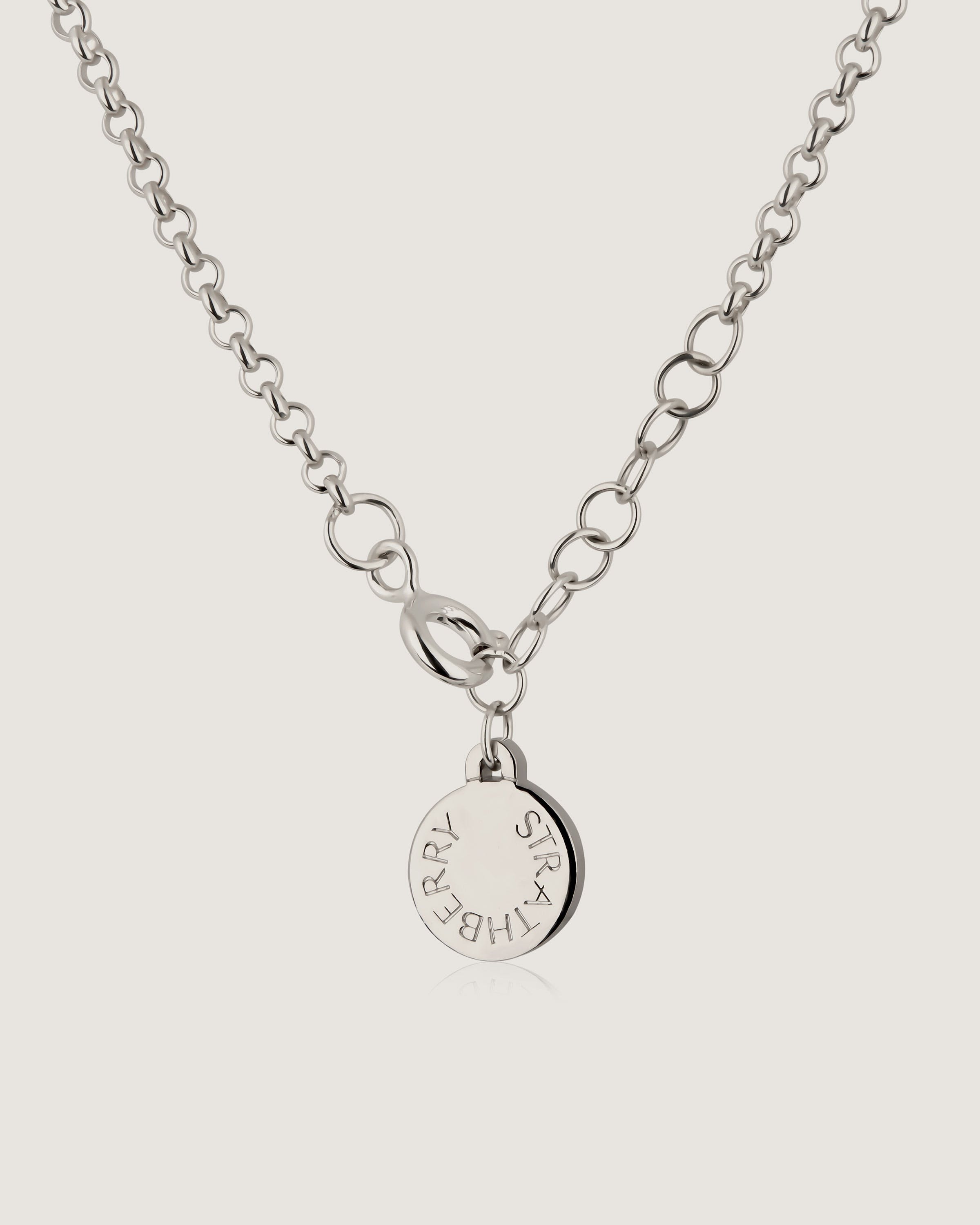 A silver necklace with a small disc on a chain