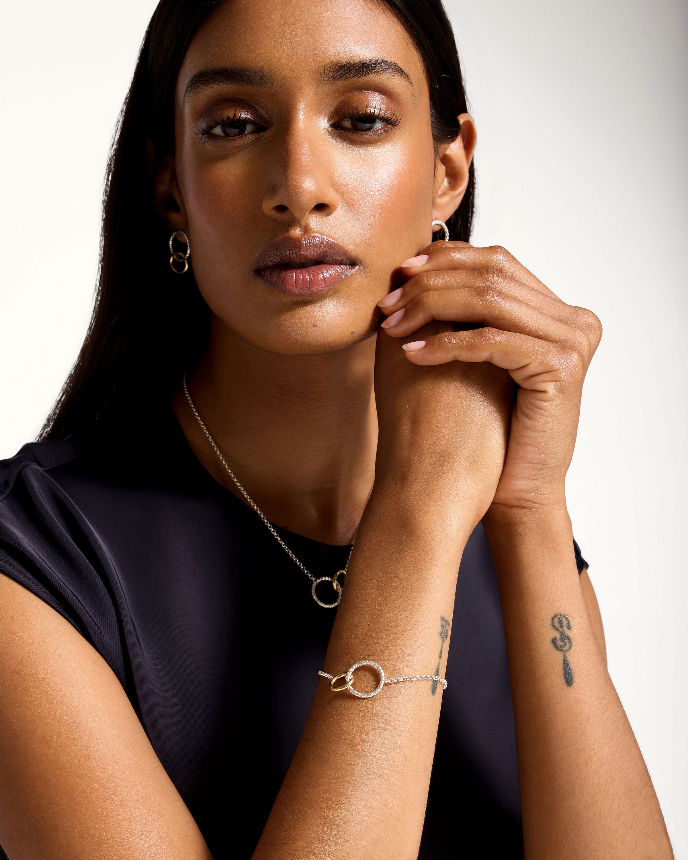 A woman wearing a black shirt and a silver bracelet