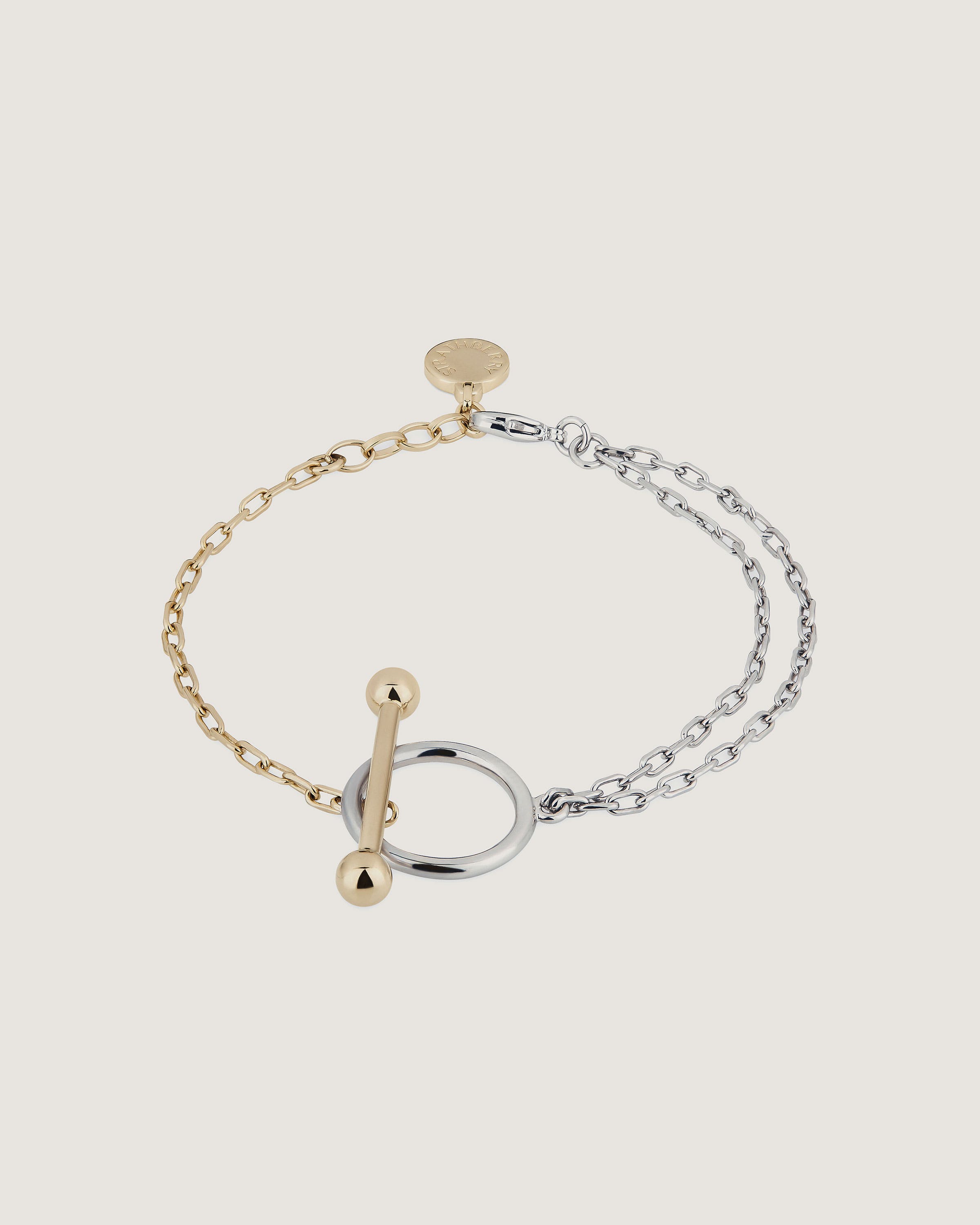 A gold and silver bracelet with a letter charm