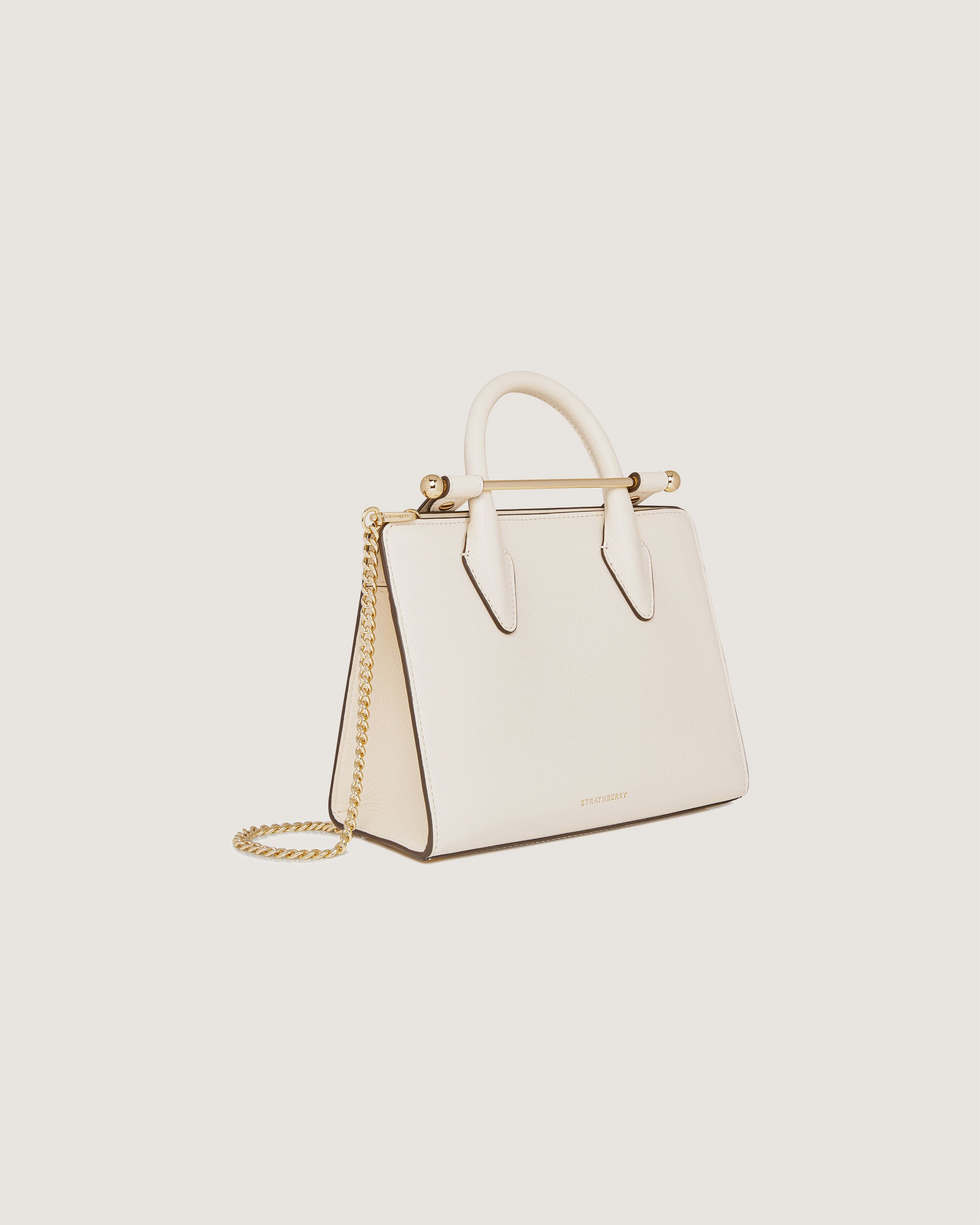 A white handbag with a gold chain