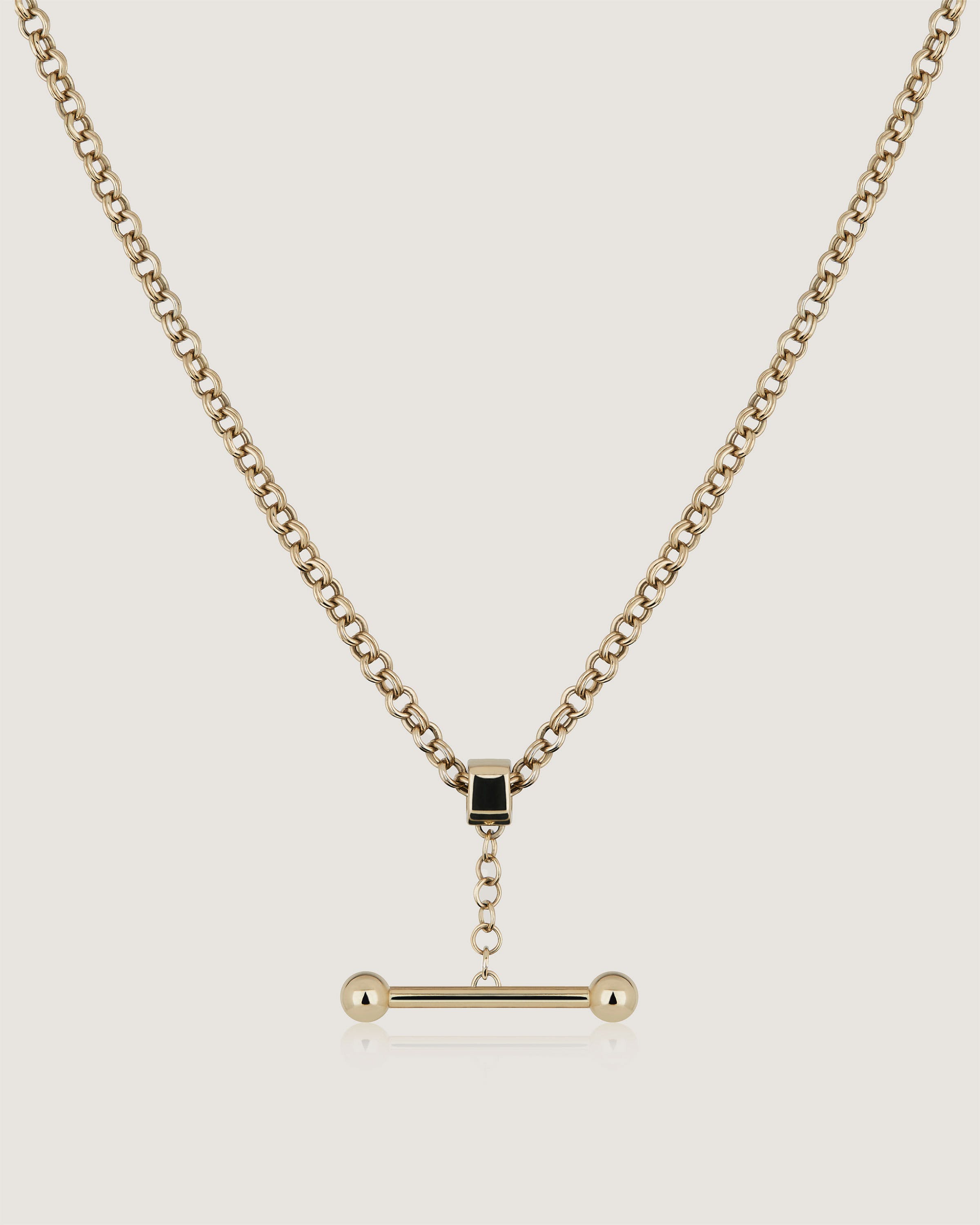 A gold chain with a bar on it