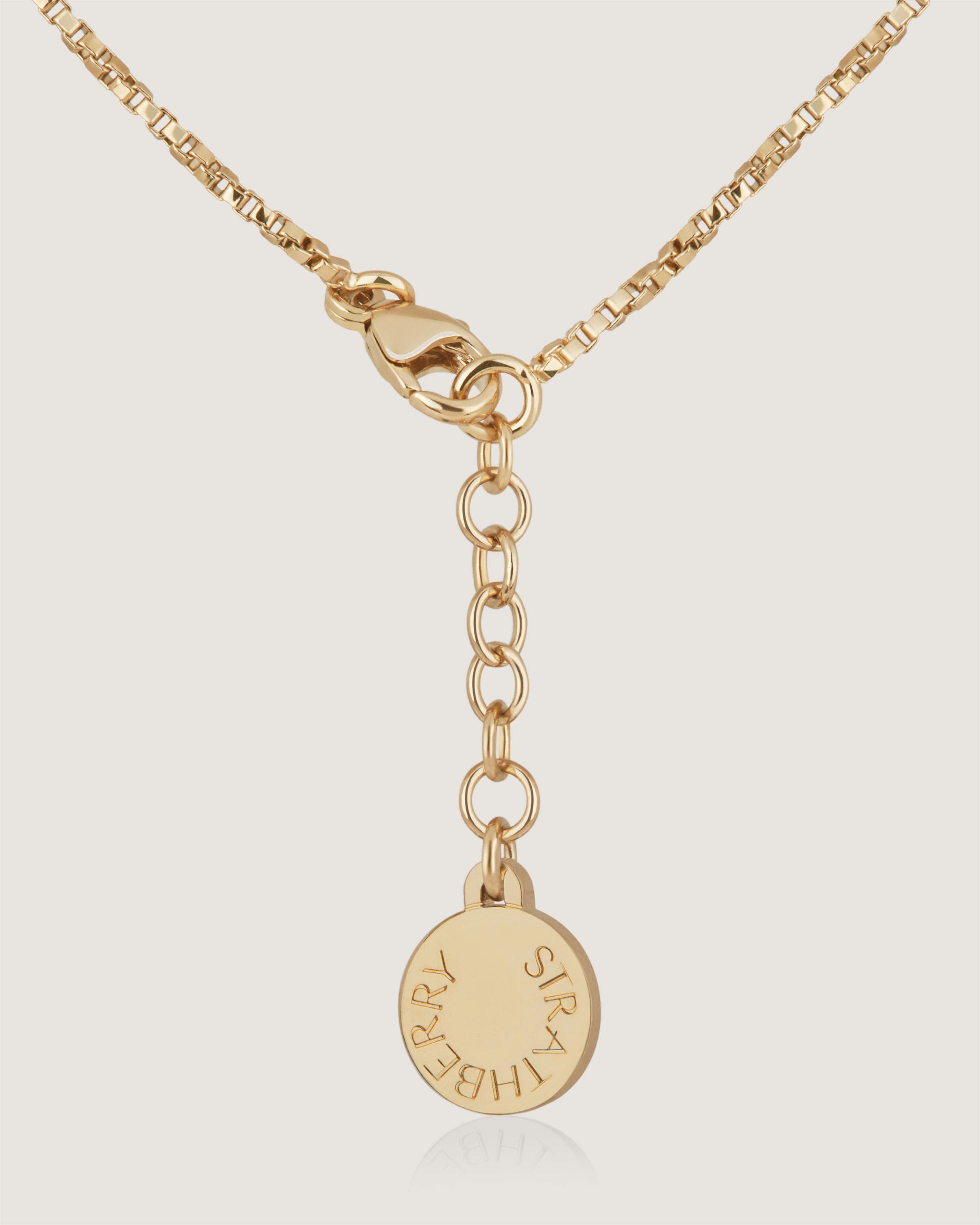 A gold plated necklace with a name charm