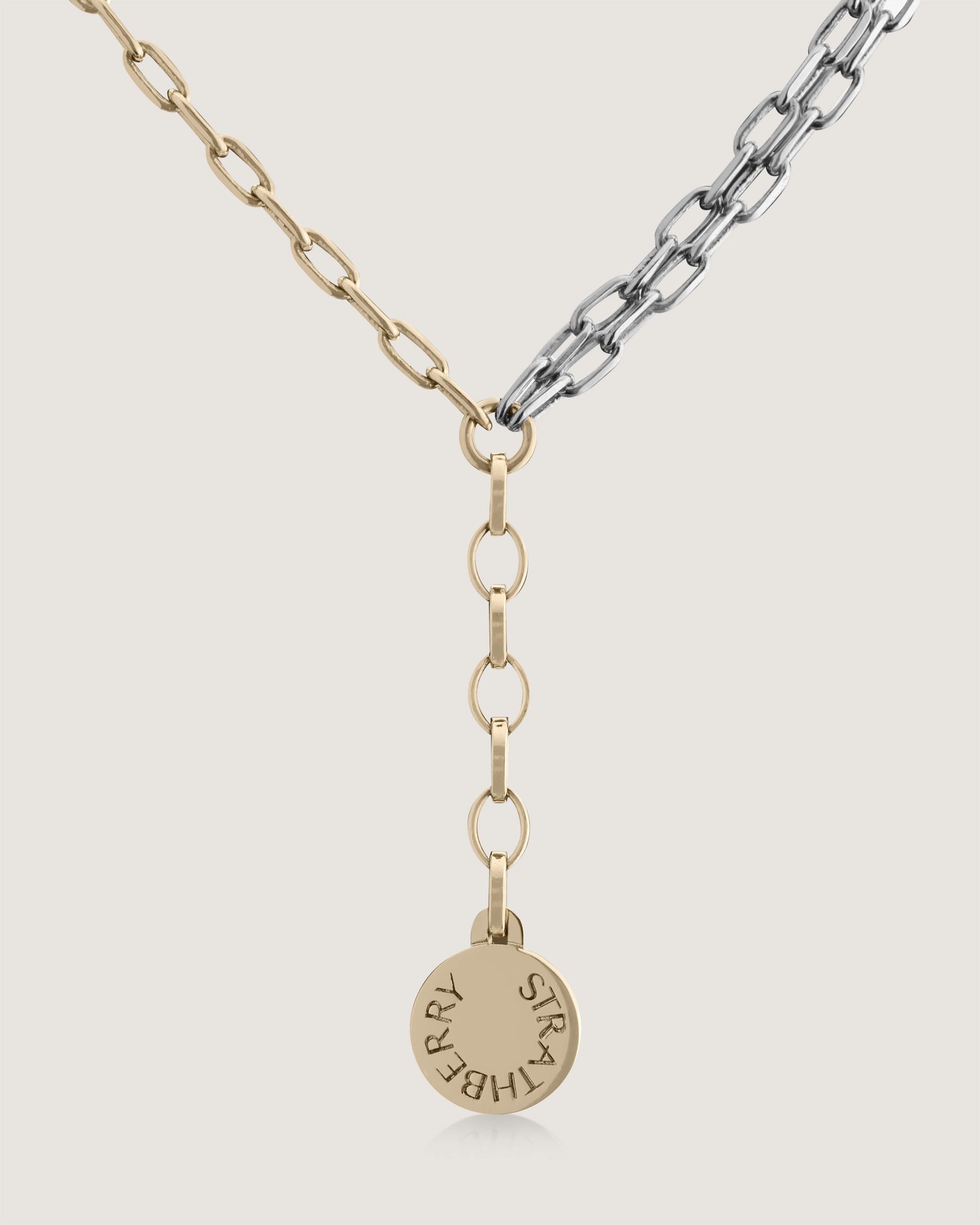 A gold and silver necklace with a name tag on it