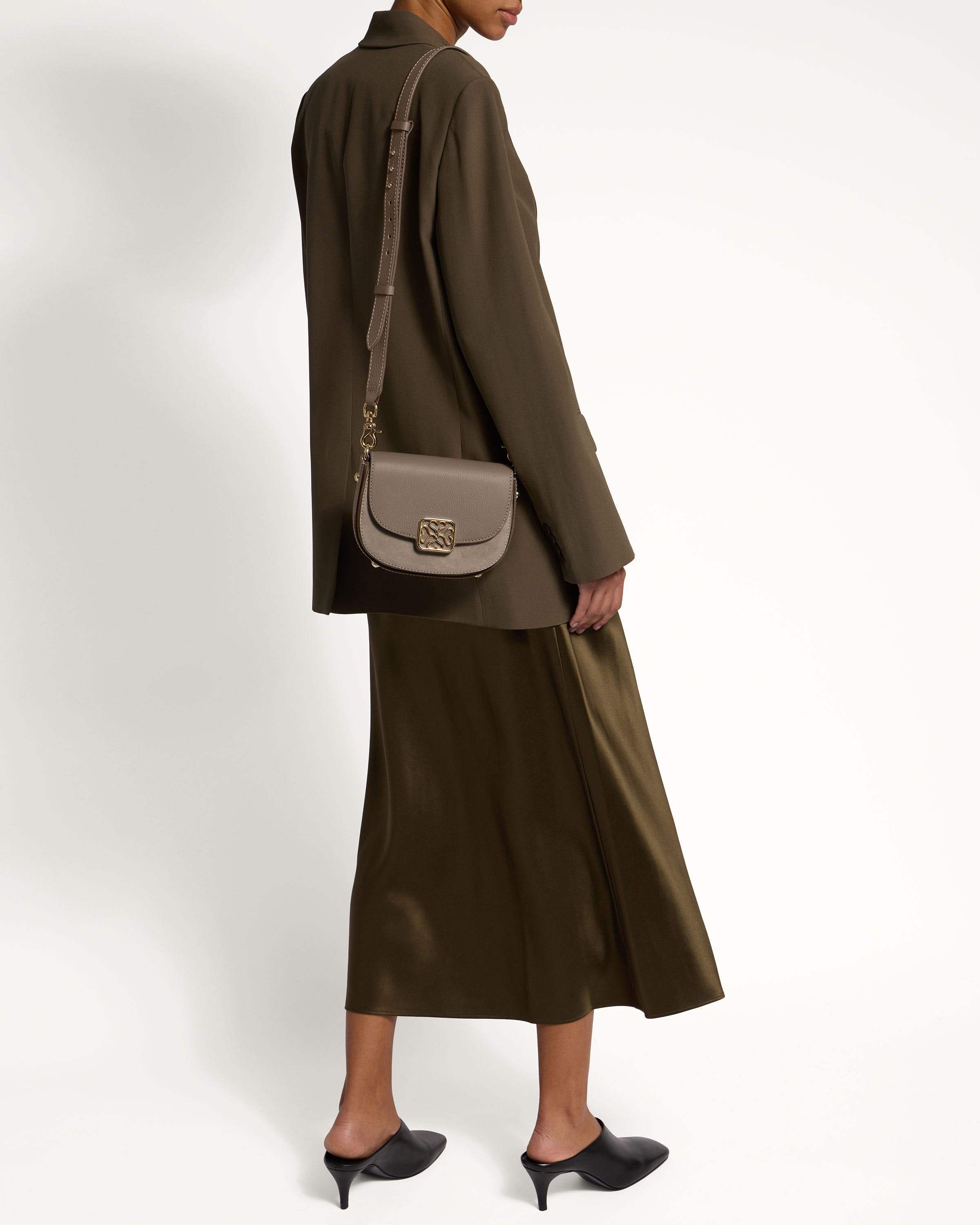 A woman wearing a brown coat and a gray bag