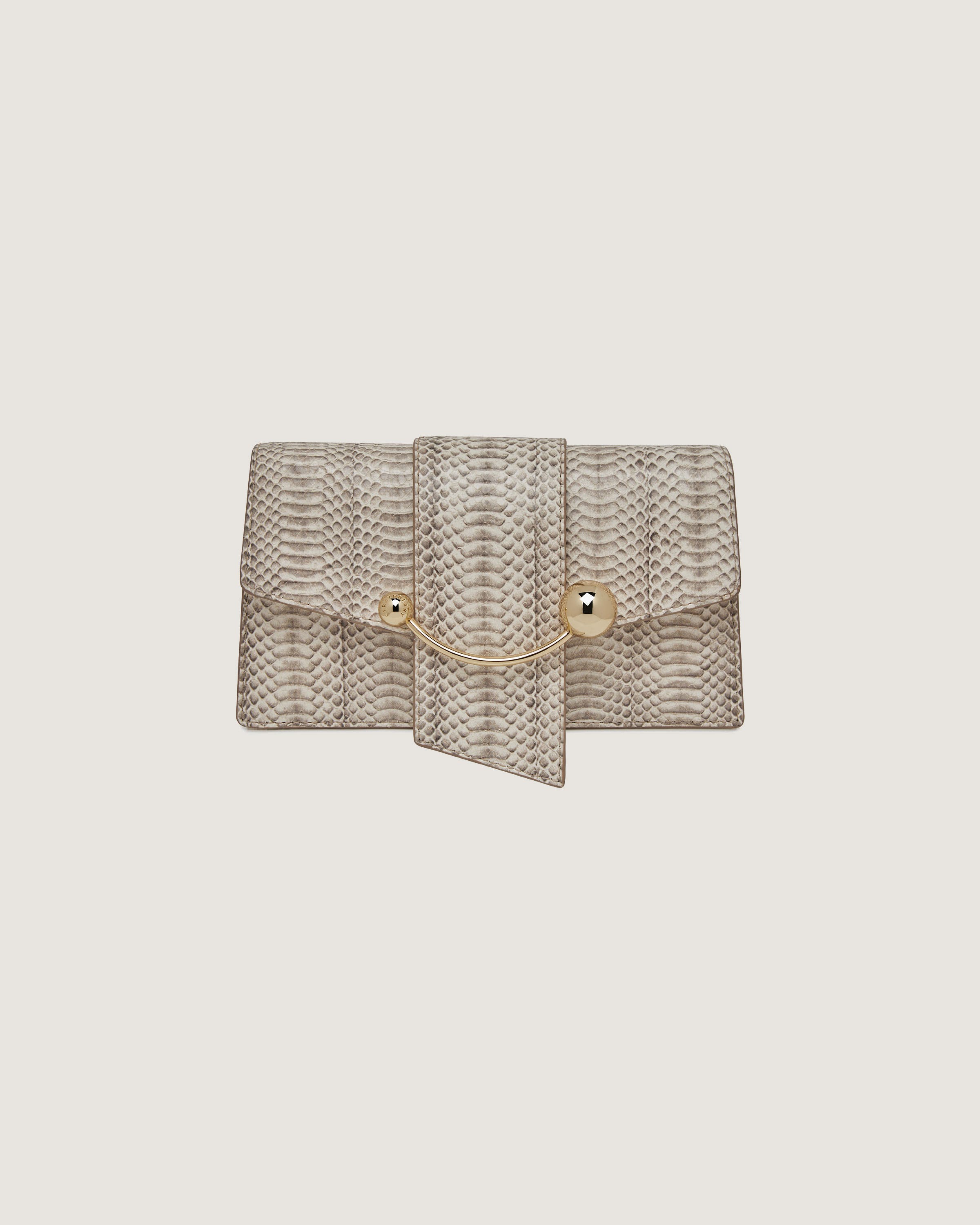 A beige snake skin purse with a gold chain