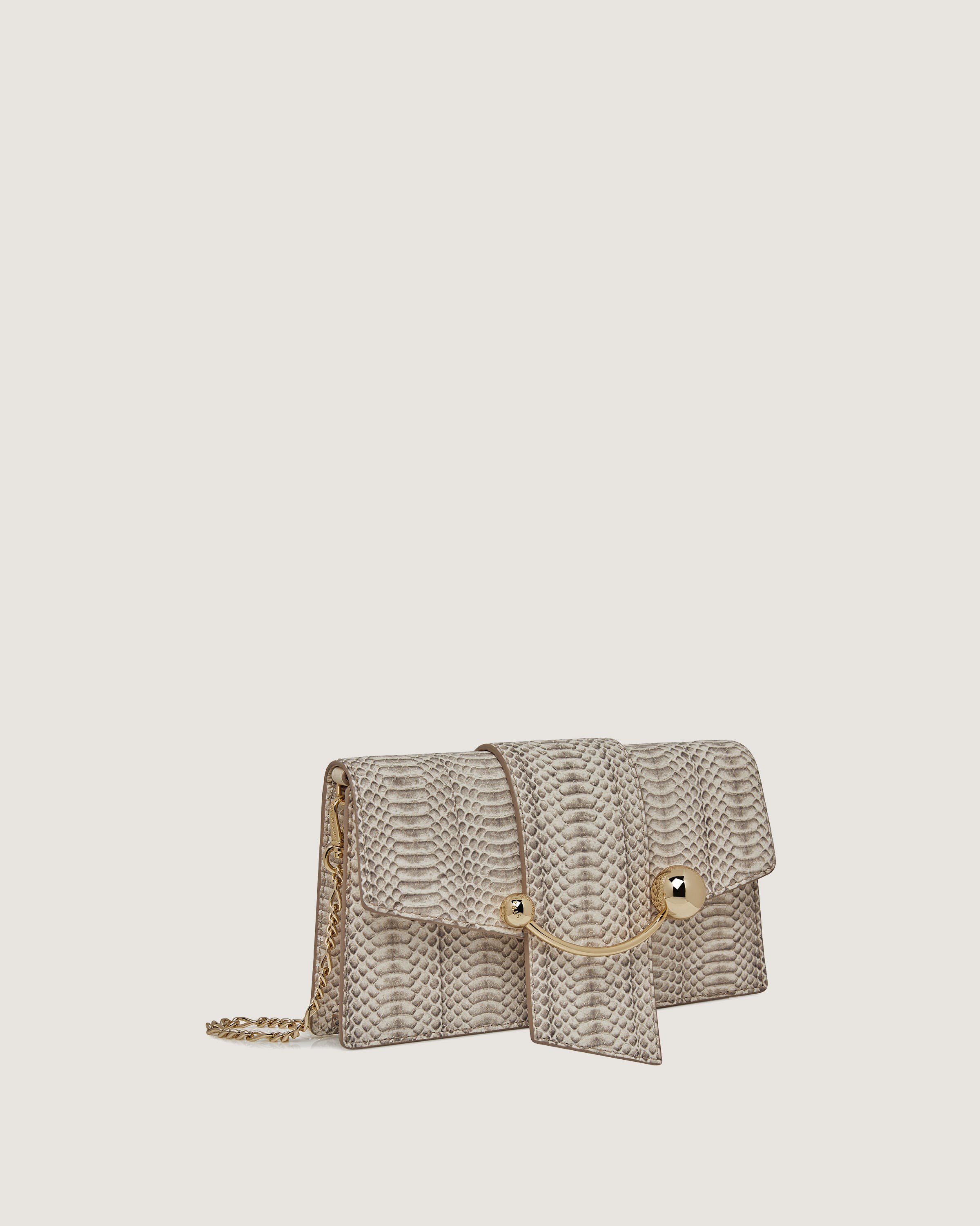 A white snake skin purse with a gold chain strap