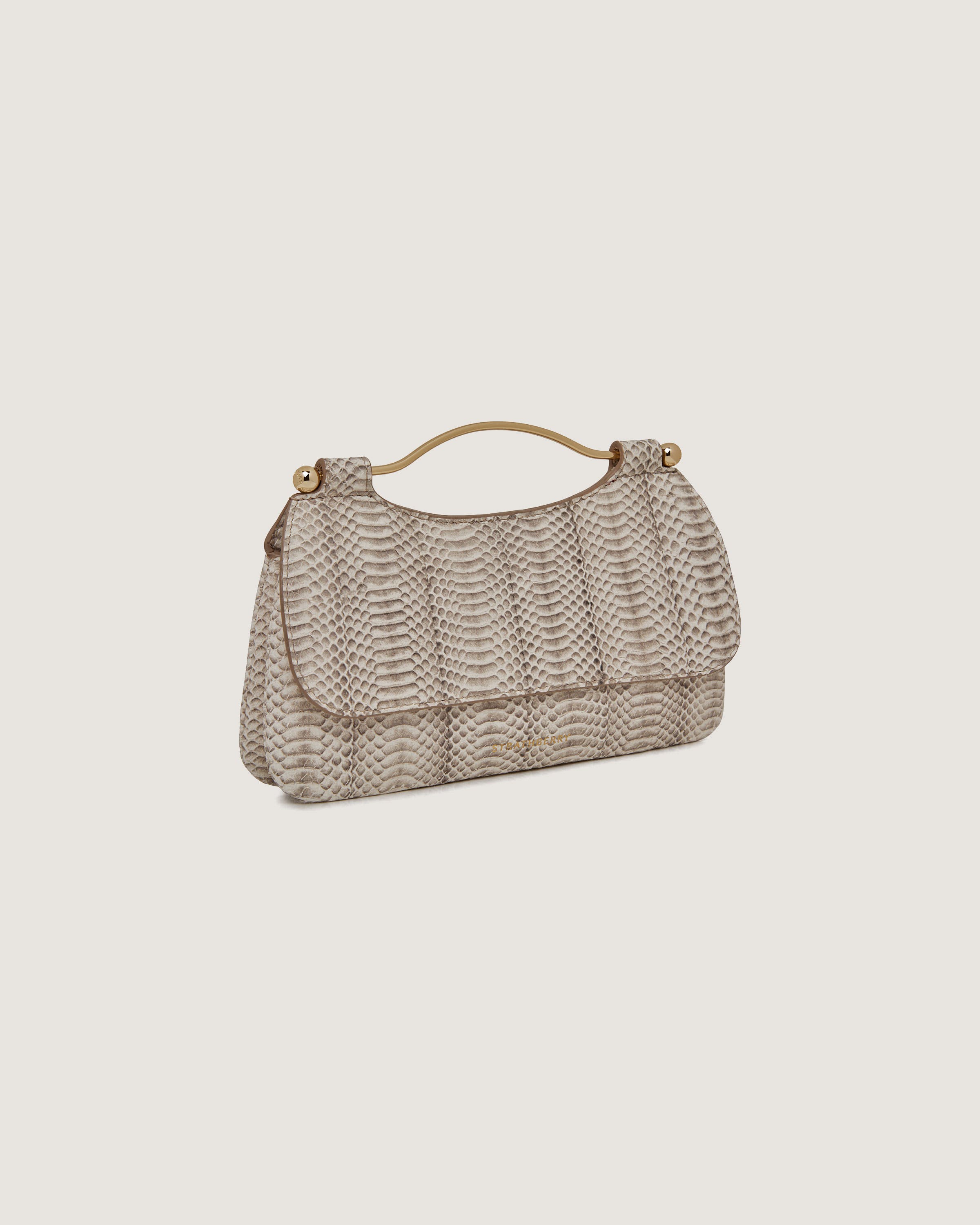 A beige handbag on a white background