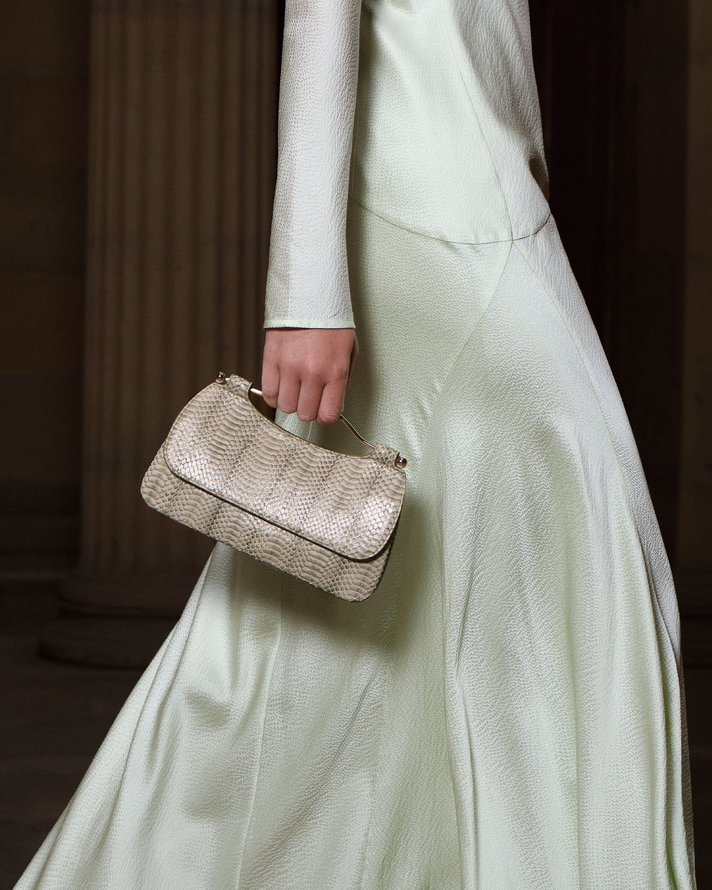 A woman in a white dress holding a purse