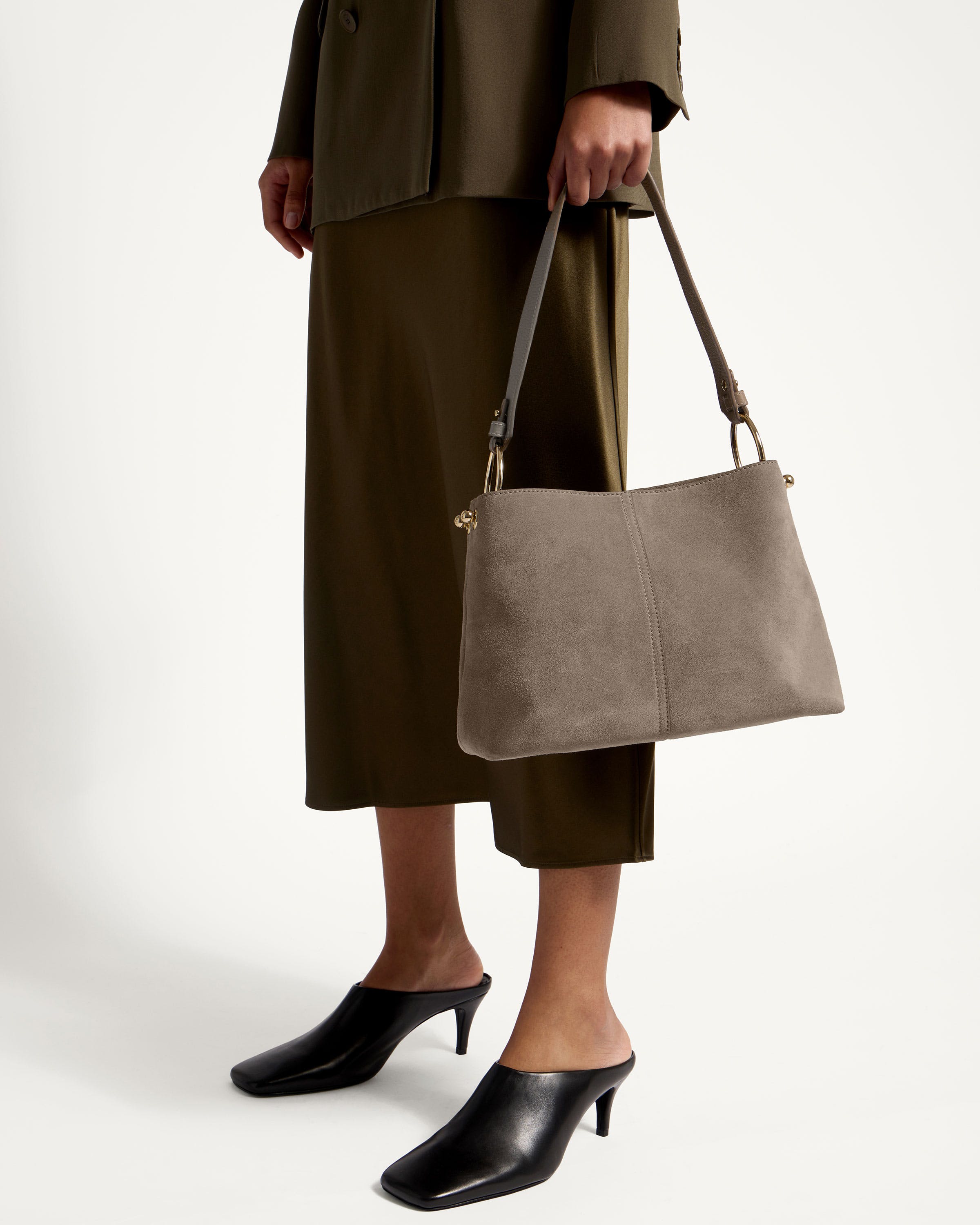 A woman is holding a gray purse