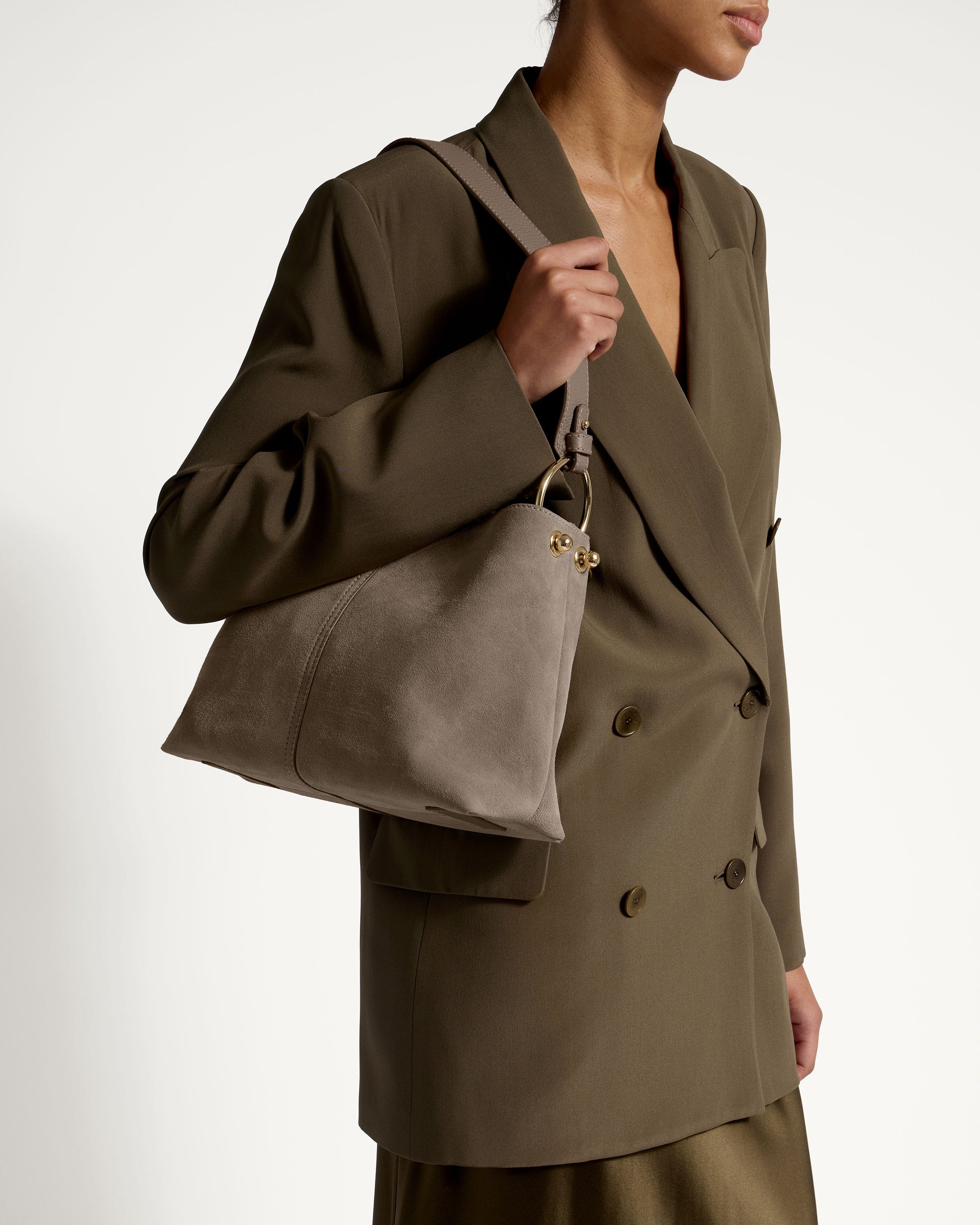 A woman in a brown suit holding a purse