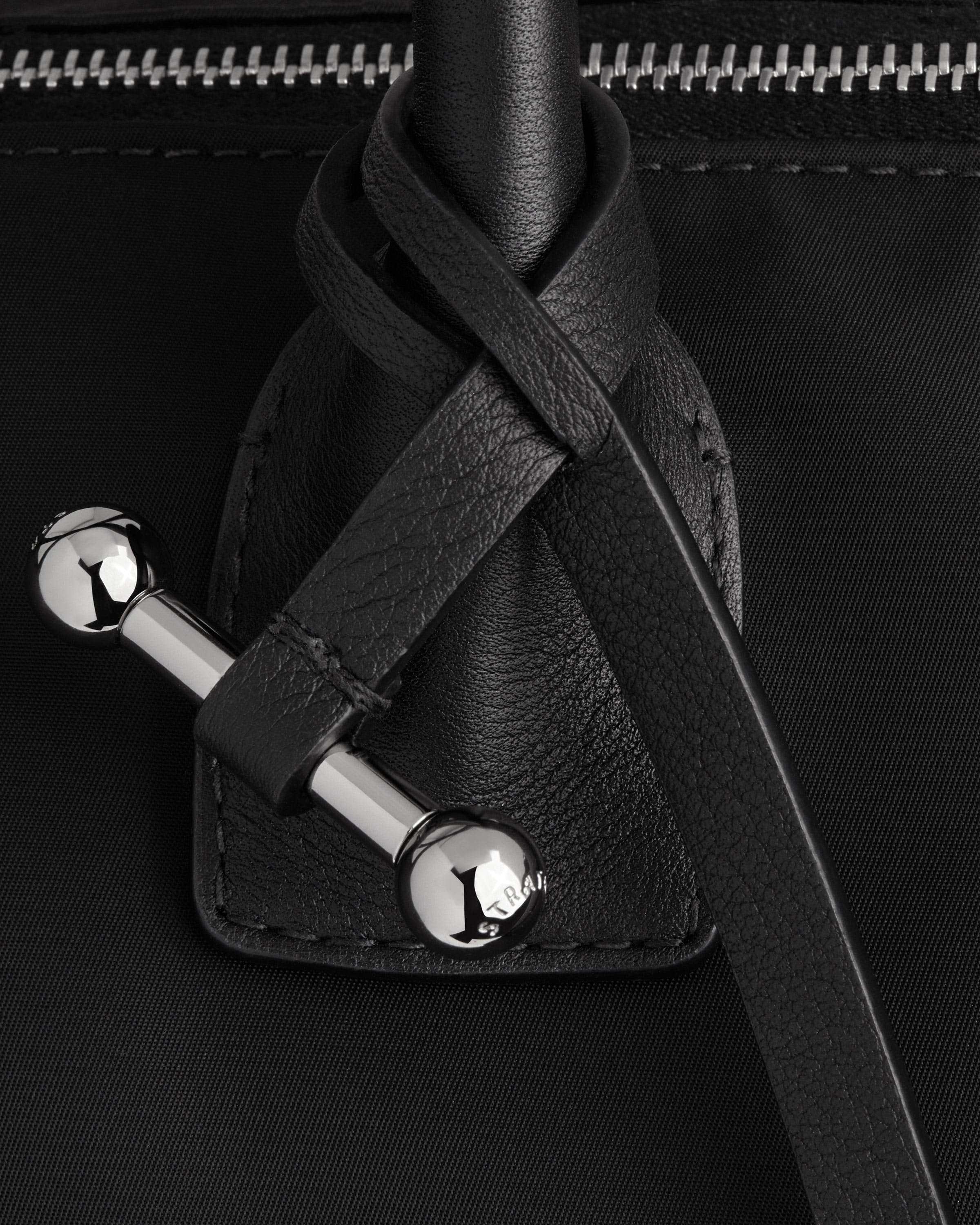 A close up of a black bag with a metal handle