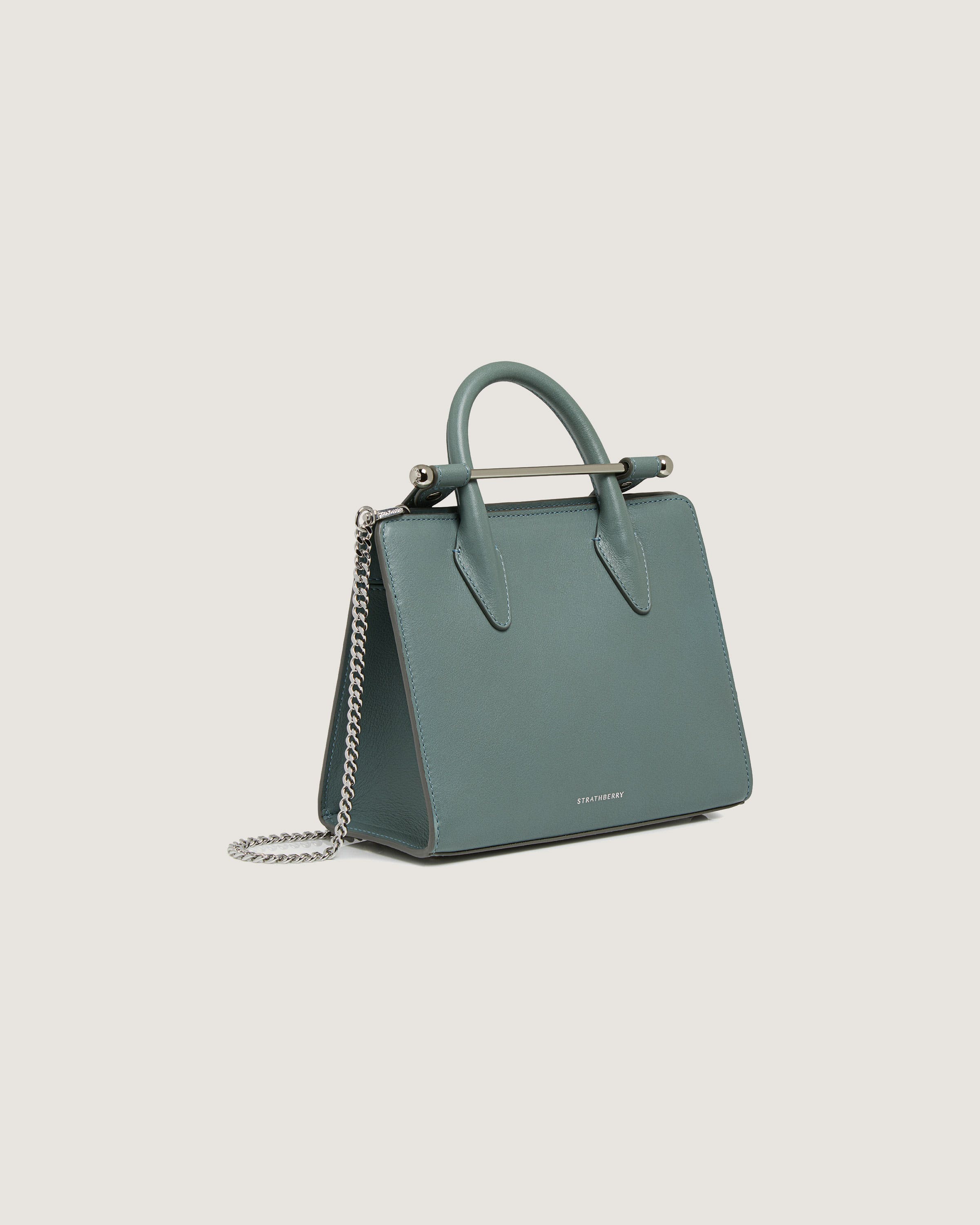 A green handbag with a chain hanging from it