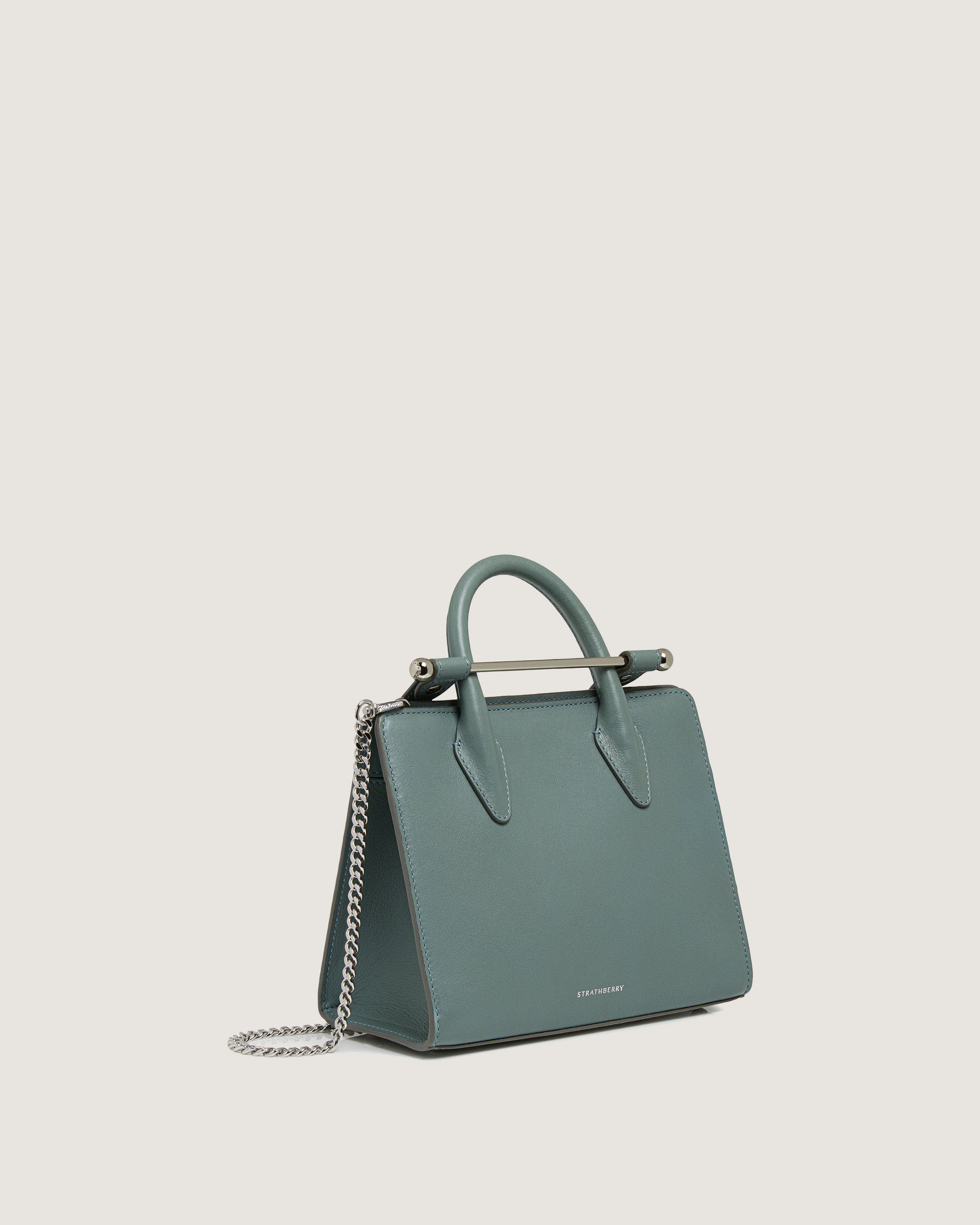 A green handbag with a chain hanging from it