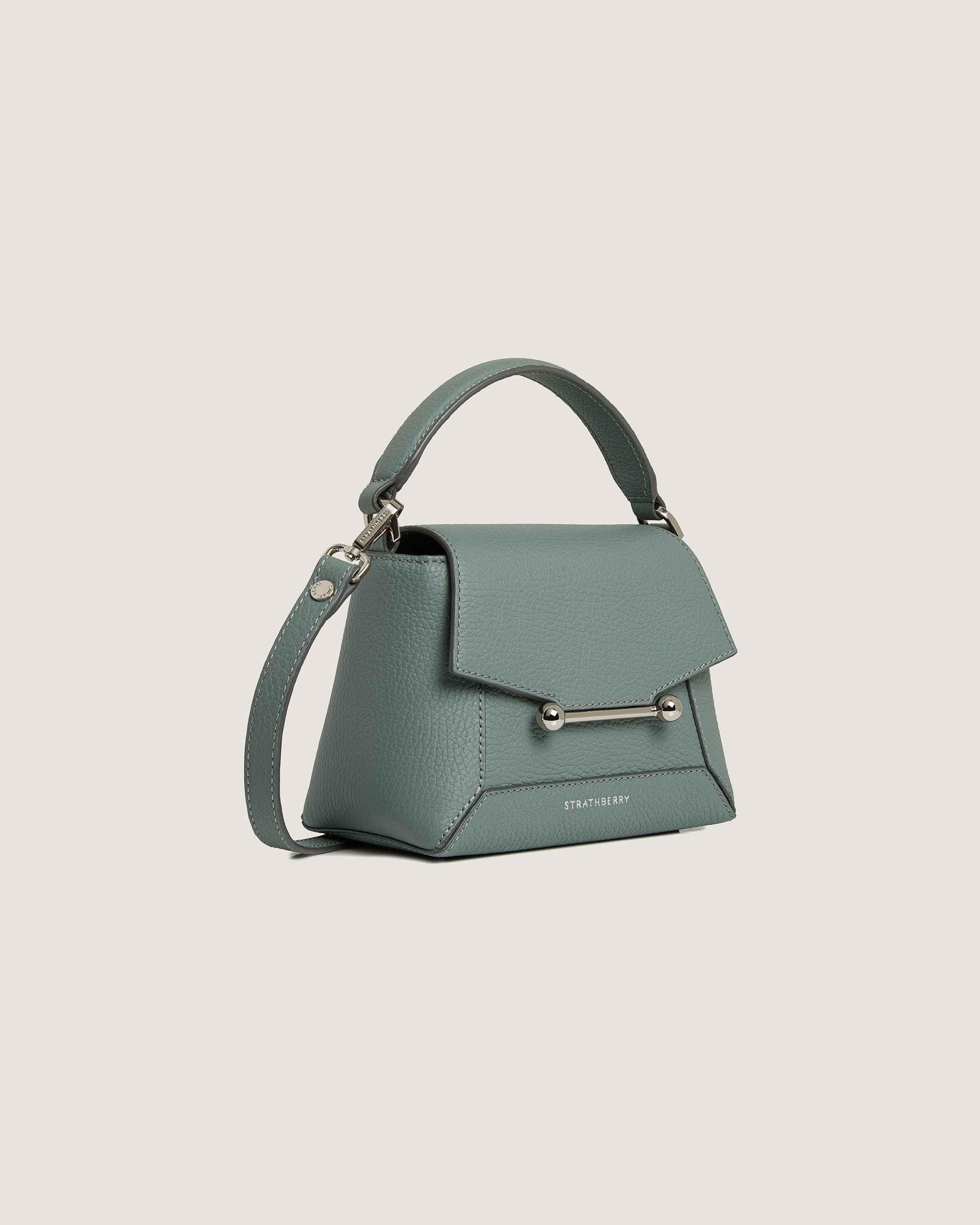 A green handbag with a metal handle