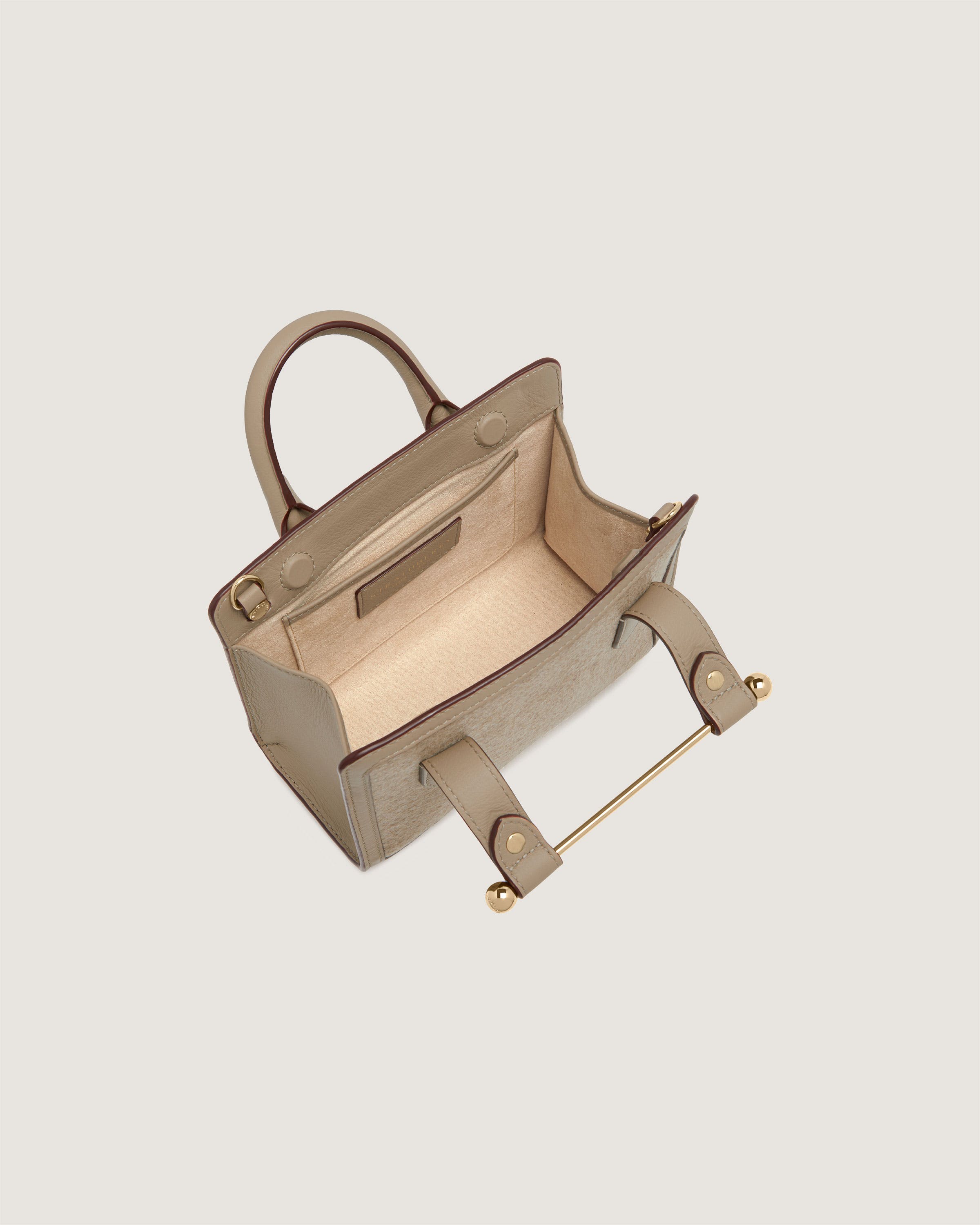 A beige leather handbag on a white background