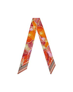 An orange and pink scarf with a flower pattern