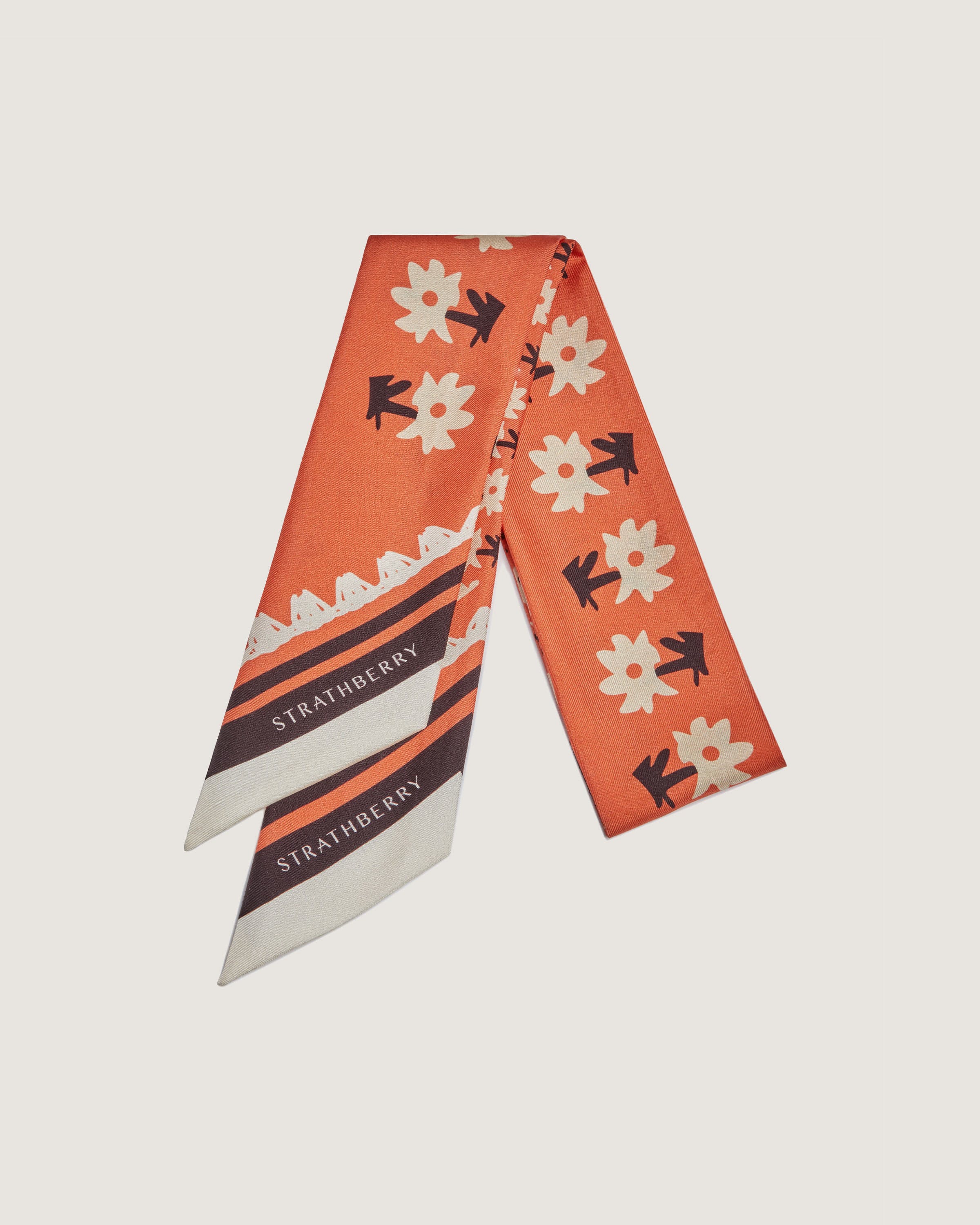 An orange scarf with black and white flowers on it