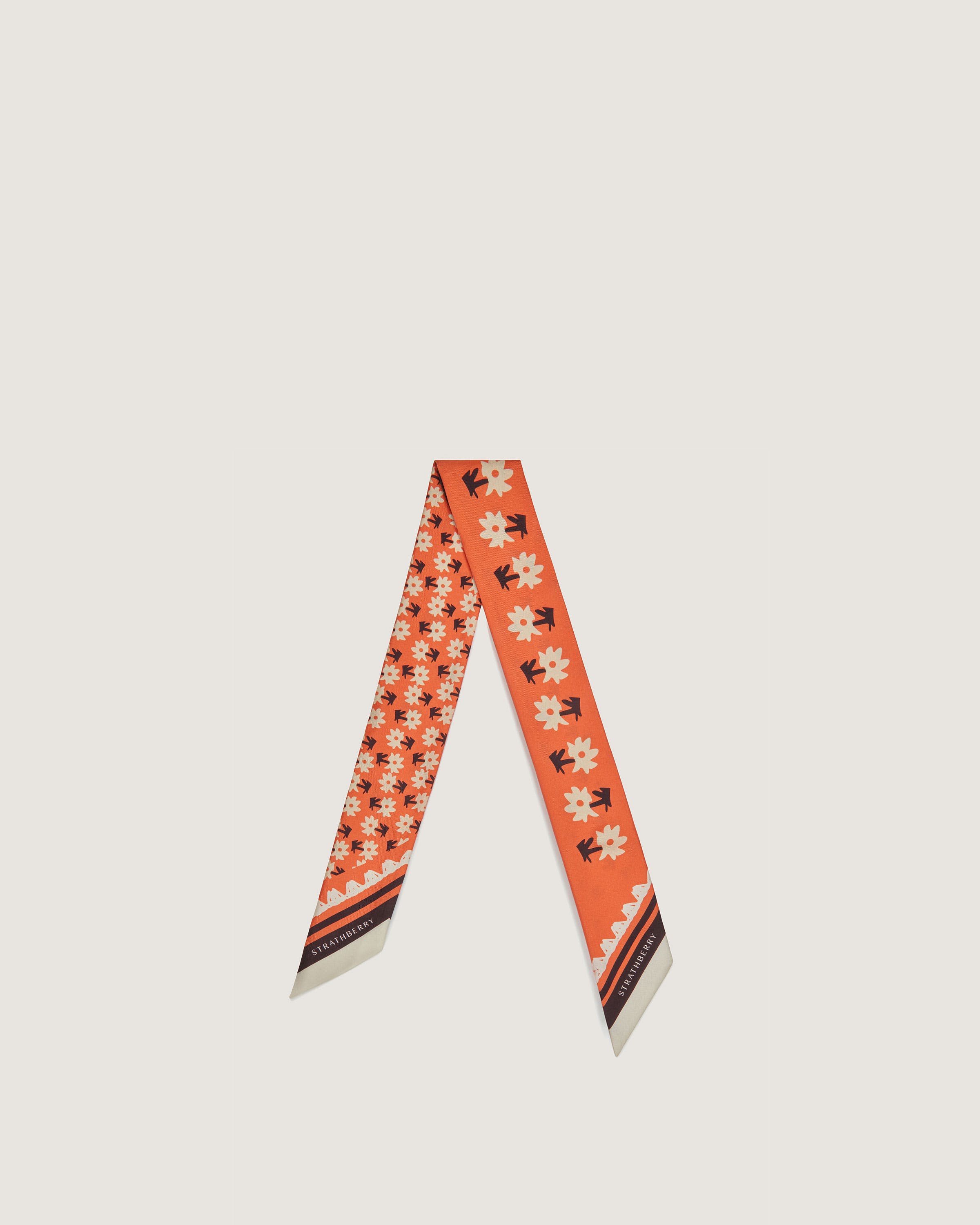 An orange neck tie with a flower design