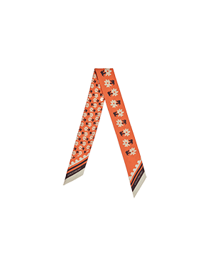 An orange and white patterned neck tie on a green background