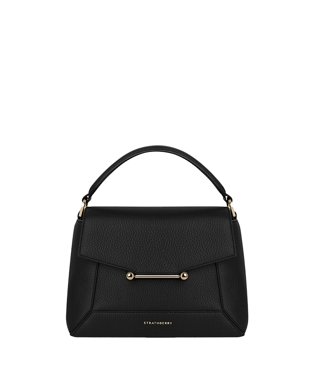 A black handbag on a green background