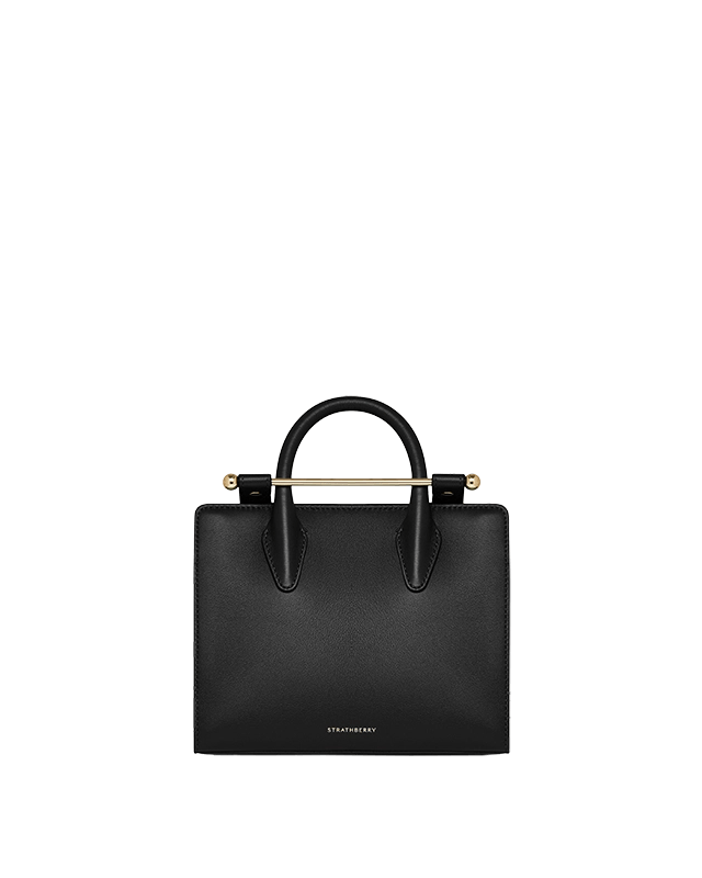 A black leather handbag on a green background