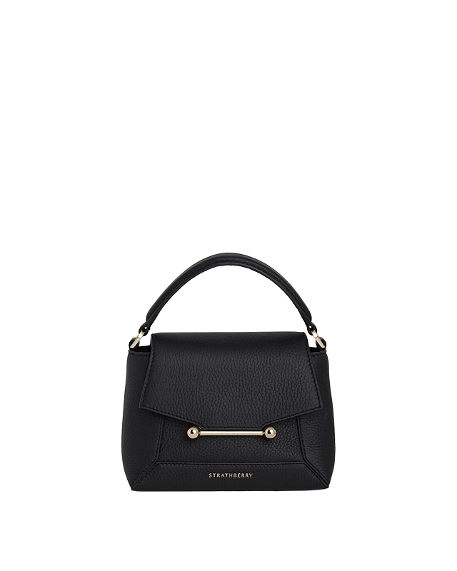 A black handbag on a green background