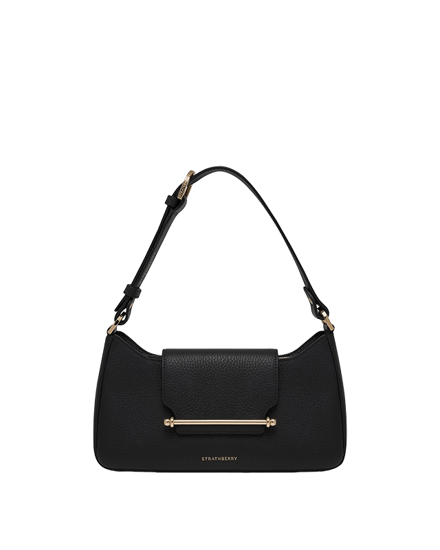 A black handbag on a green background