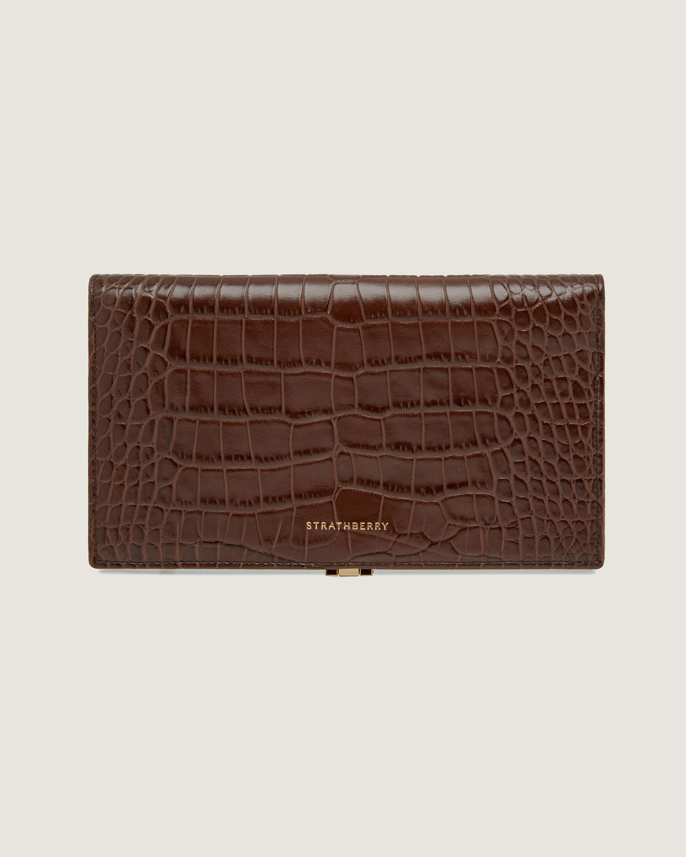 A brown alligator skin wallet with a gold clasp