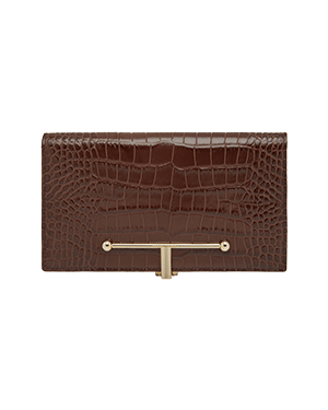 A brown alligator skin wallet with a gold metal bar