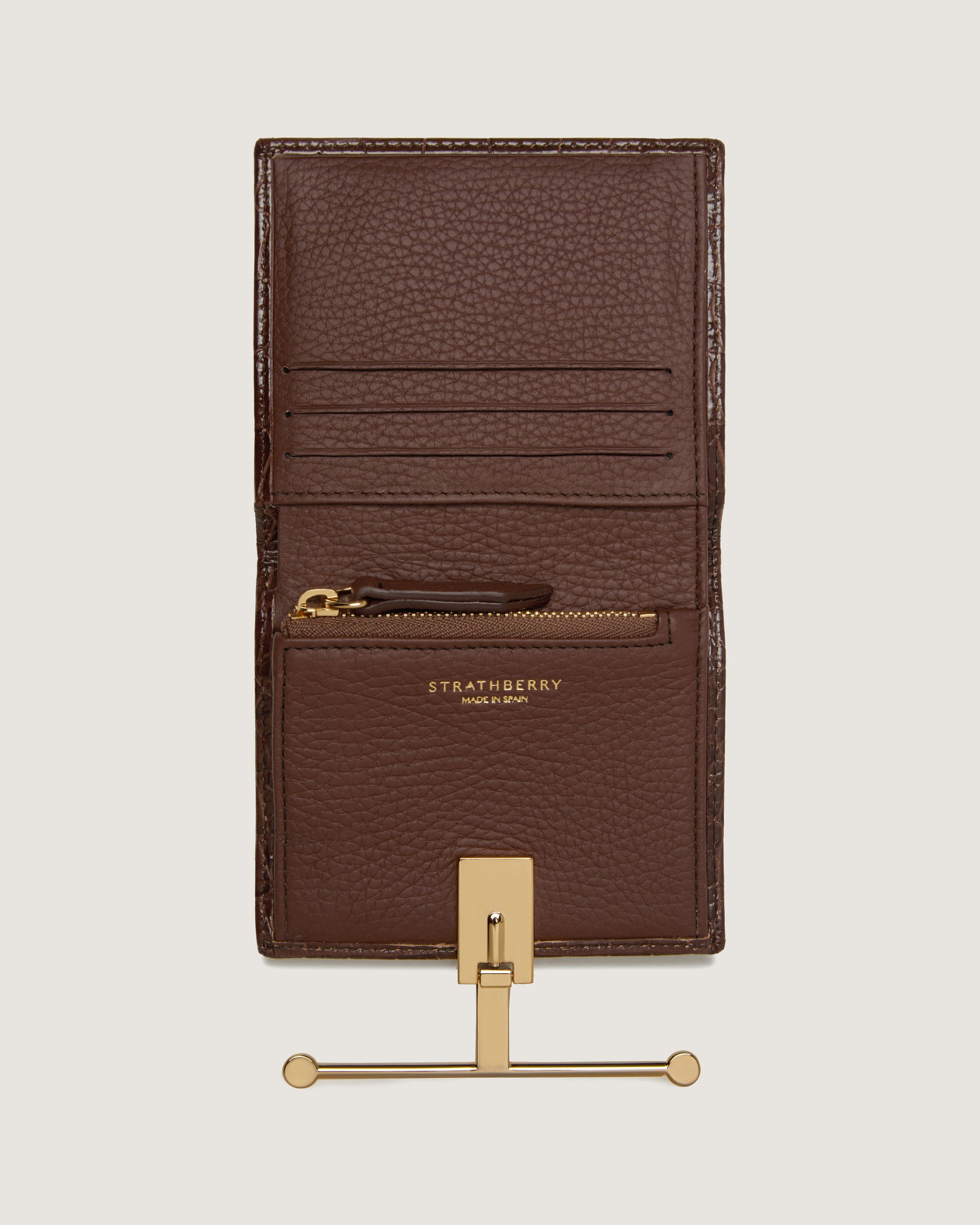 A brown card holder with a pen on top of it