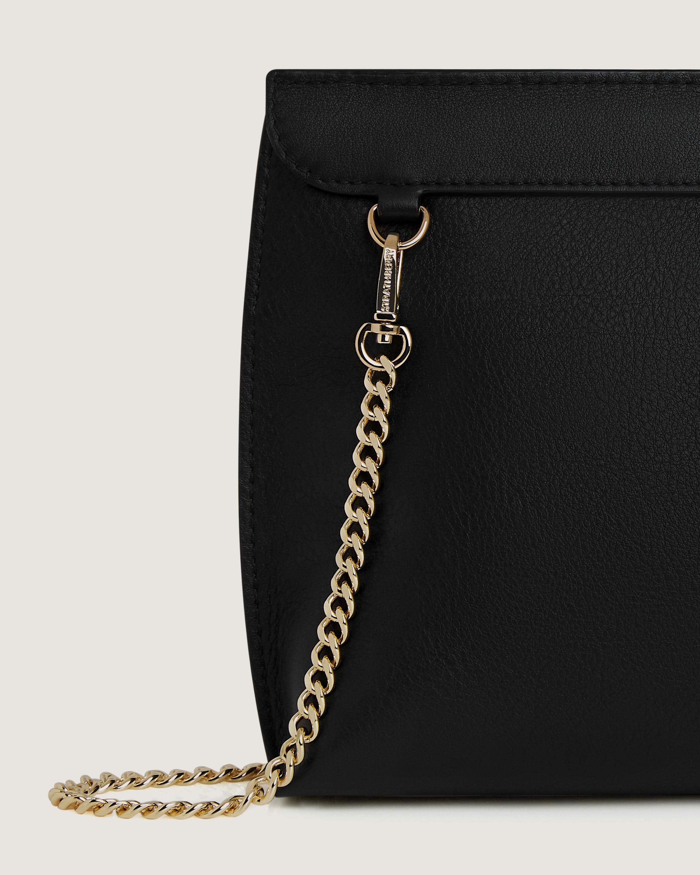 A black purse with a gold chain hanging from it