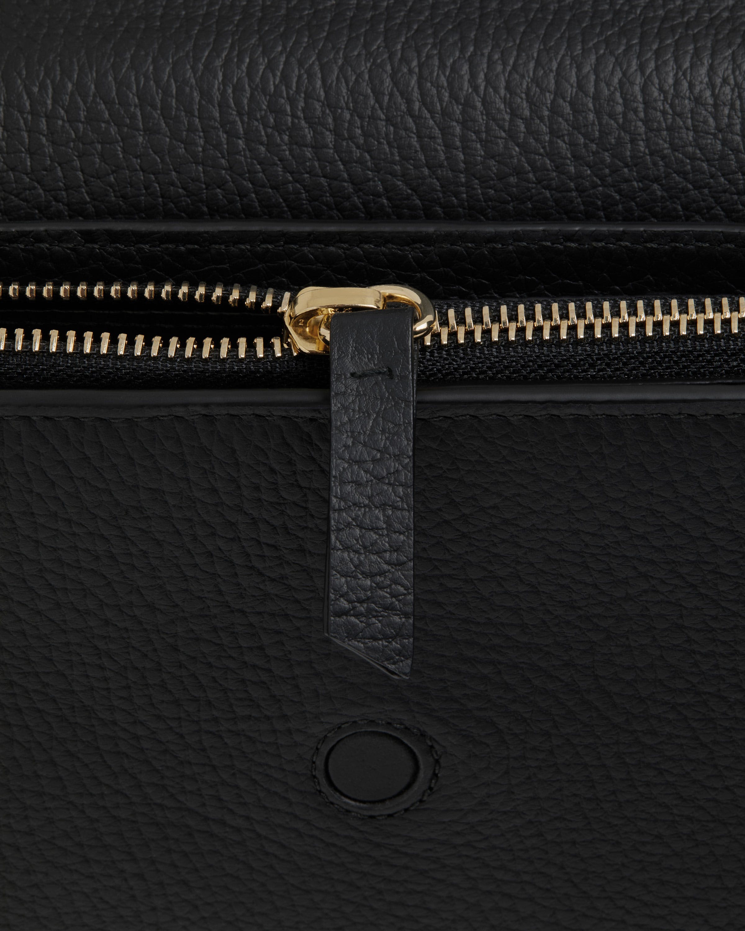 A close up of a black purse with gold zippers