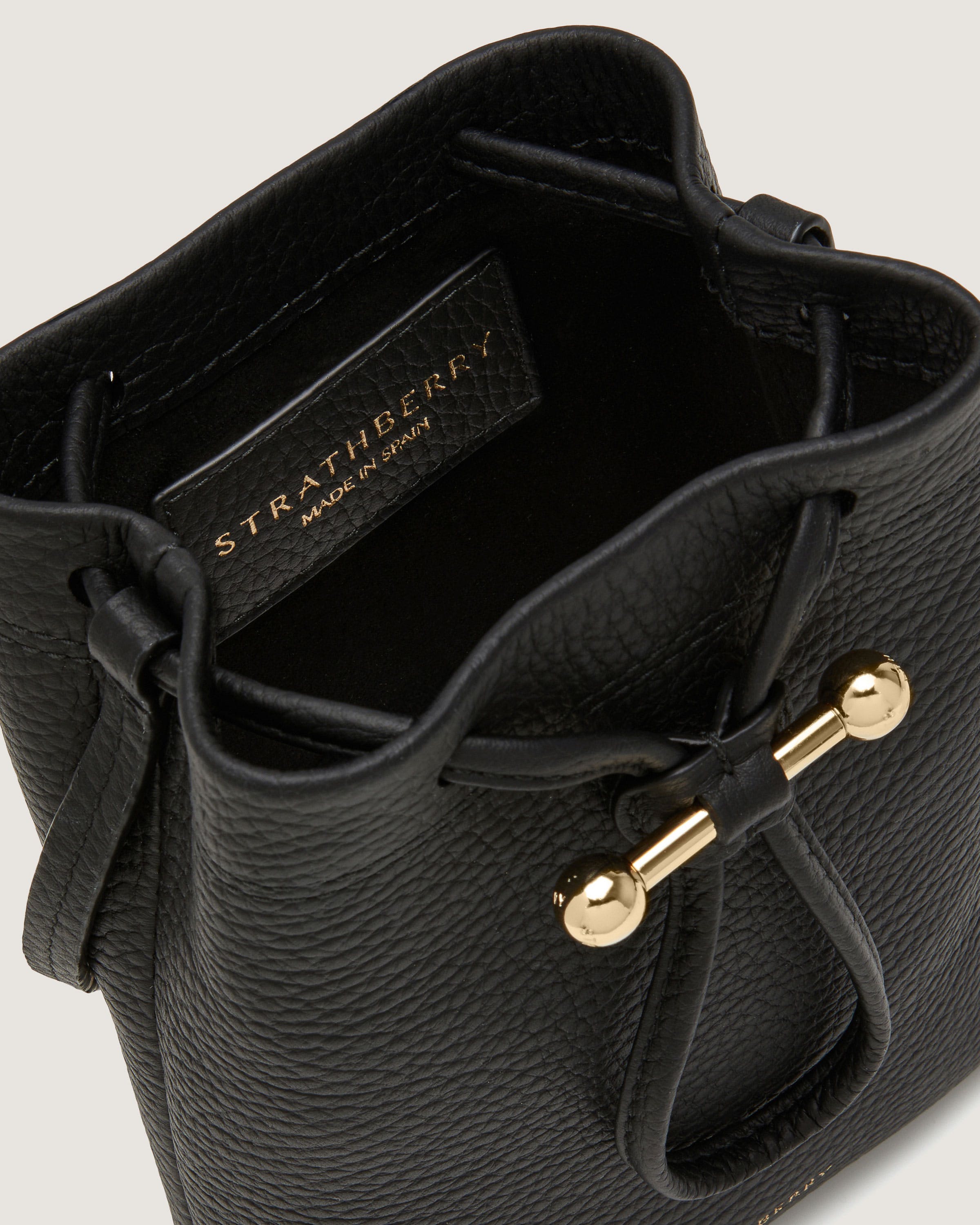 A black handbag with a gold handle