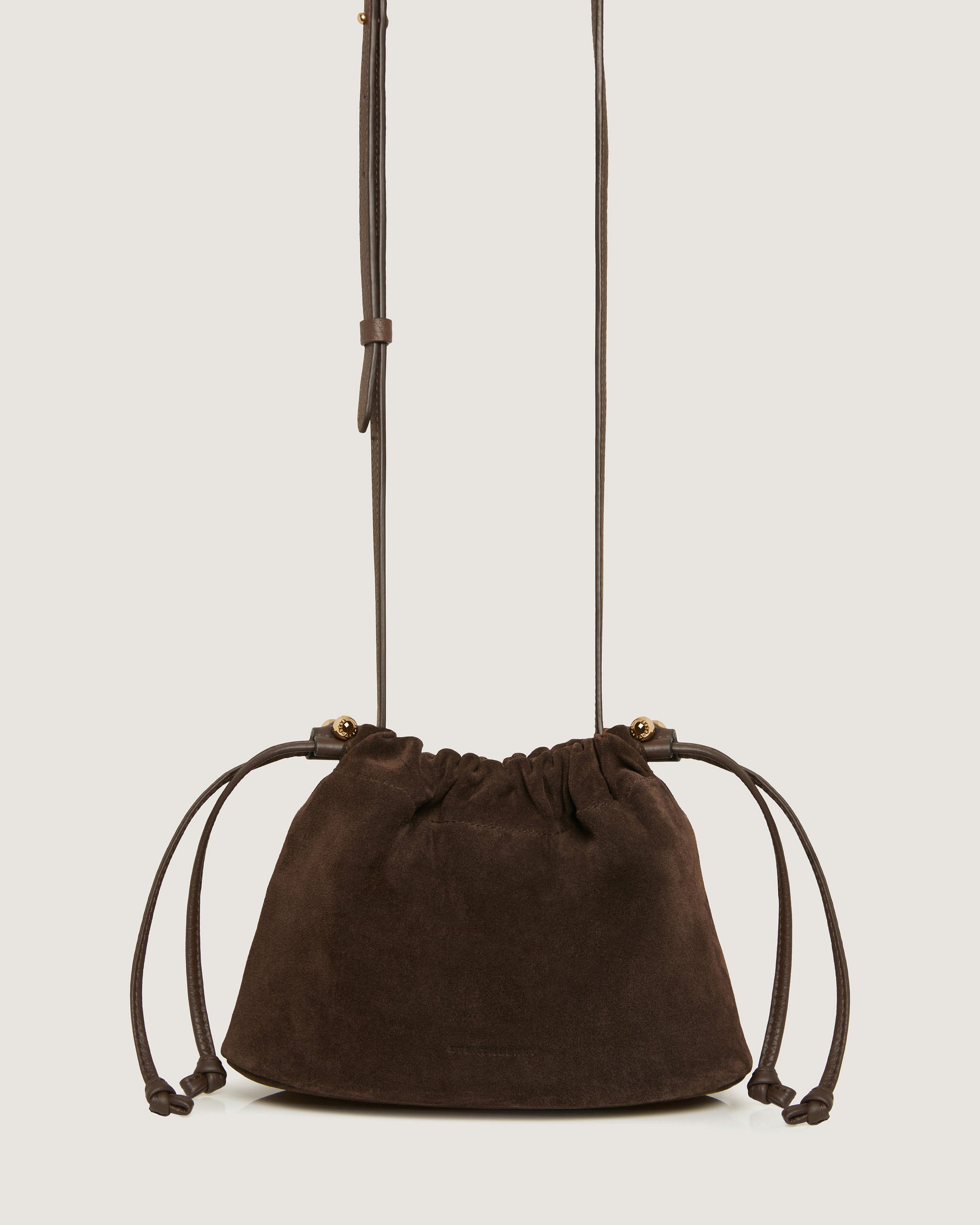 A brown sued purse with a long strap