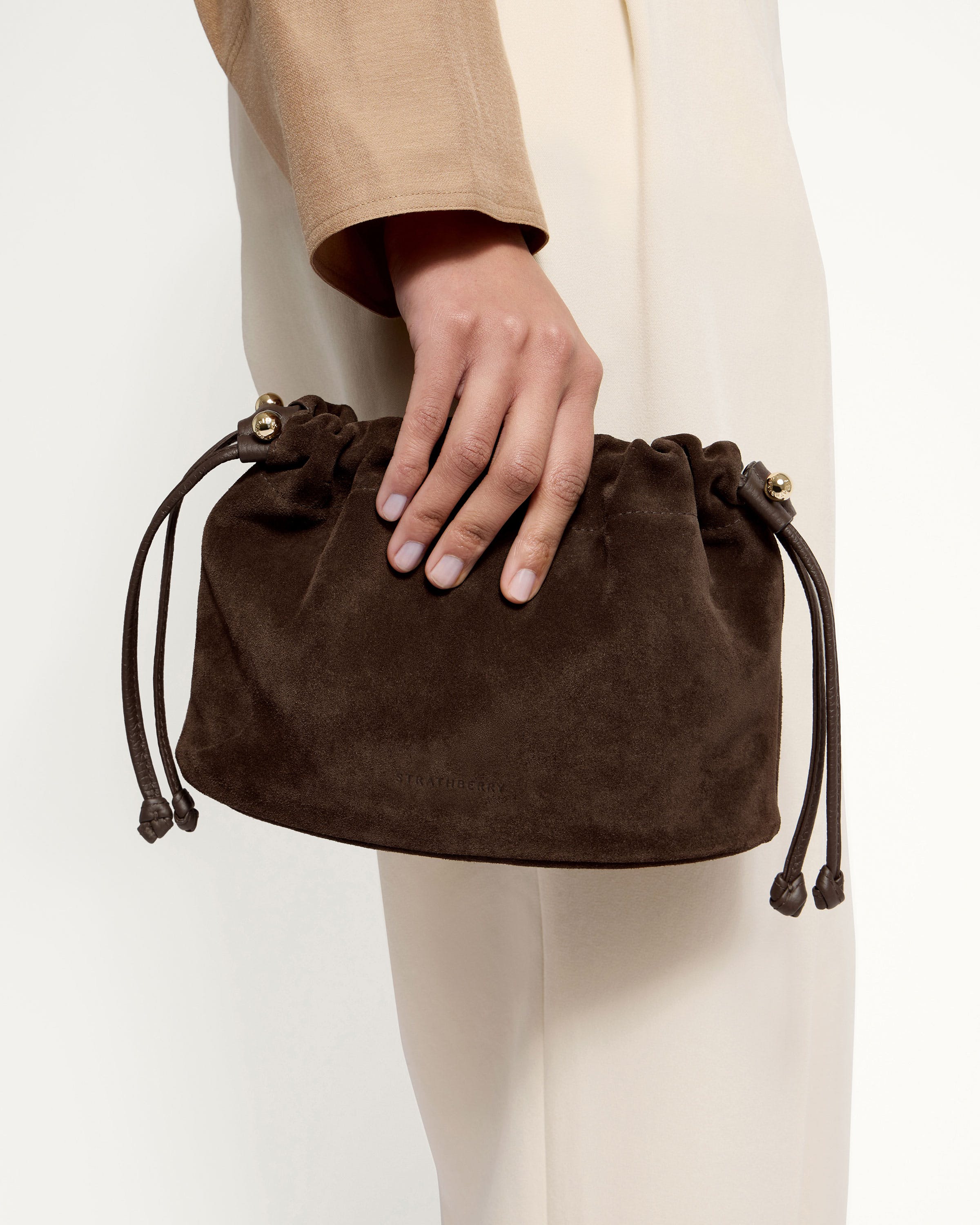 A woman's hand holding a brown purse