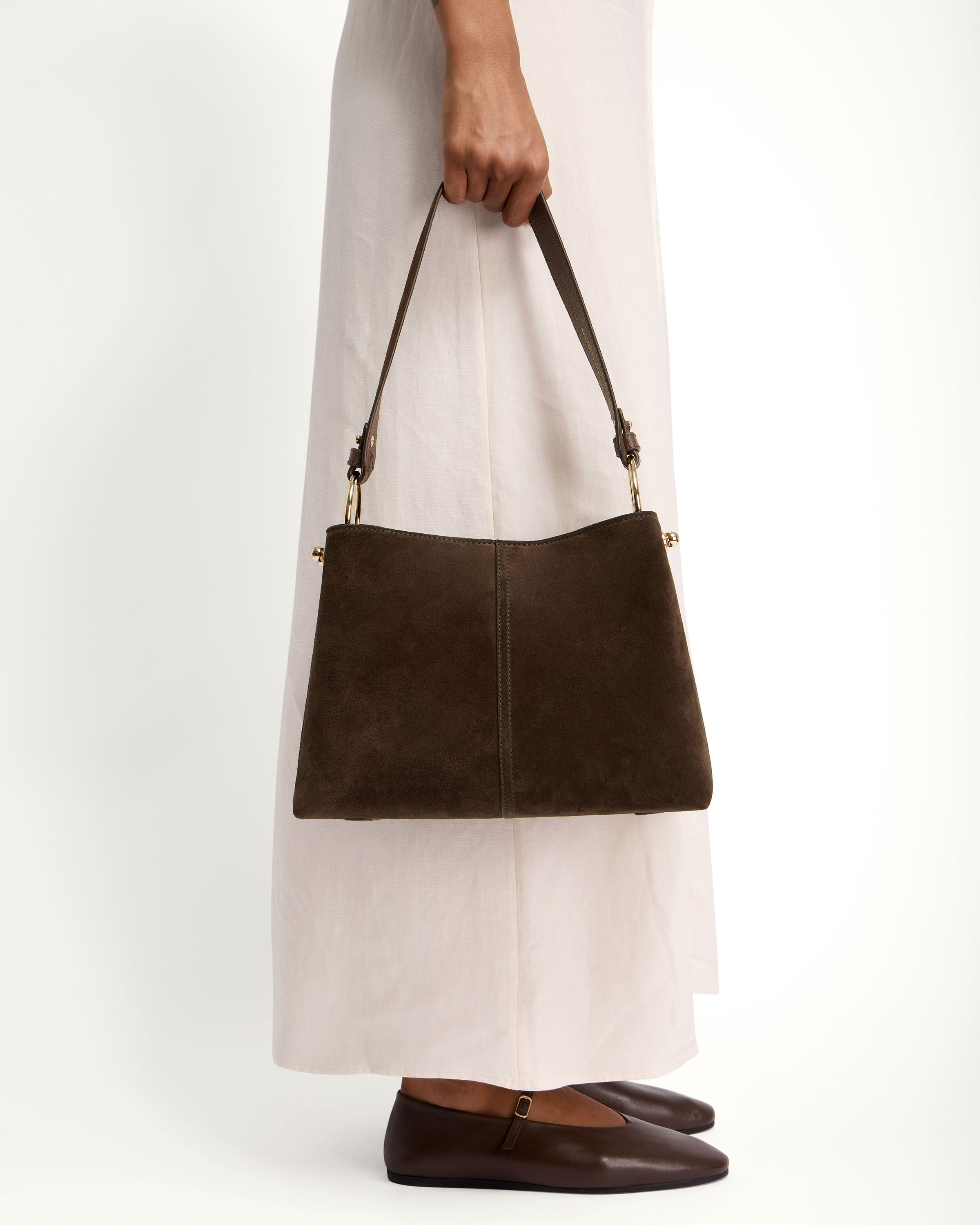 A woman is holding a brown purse