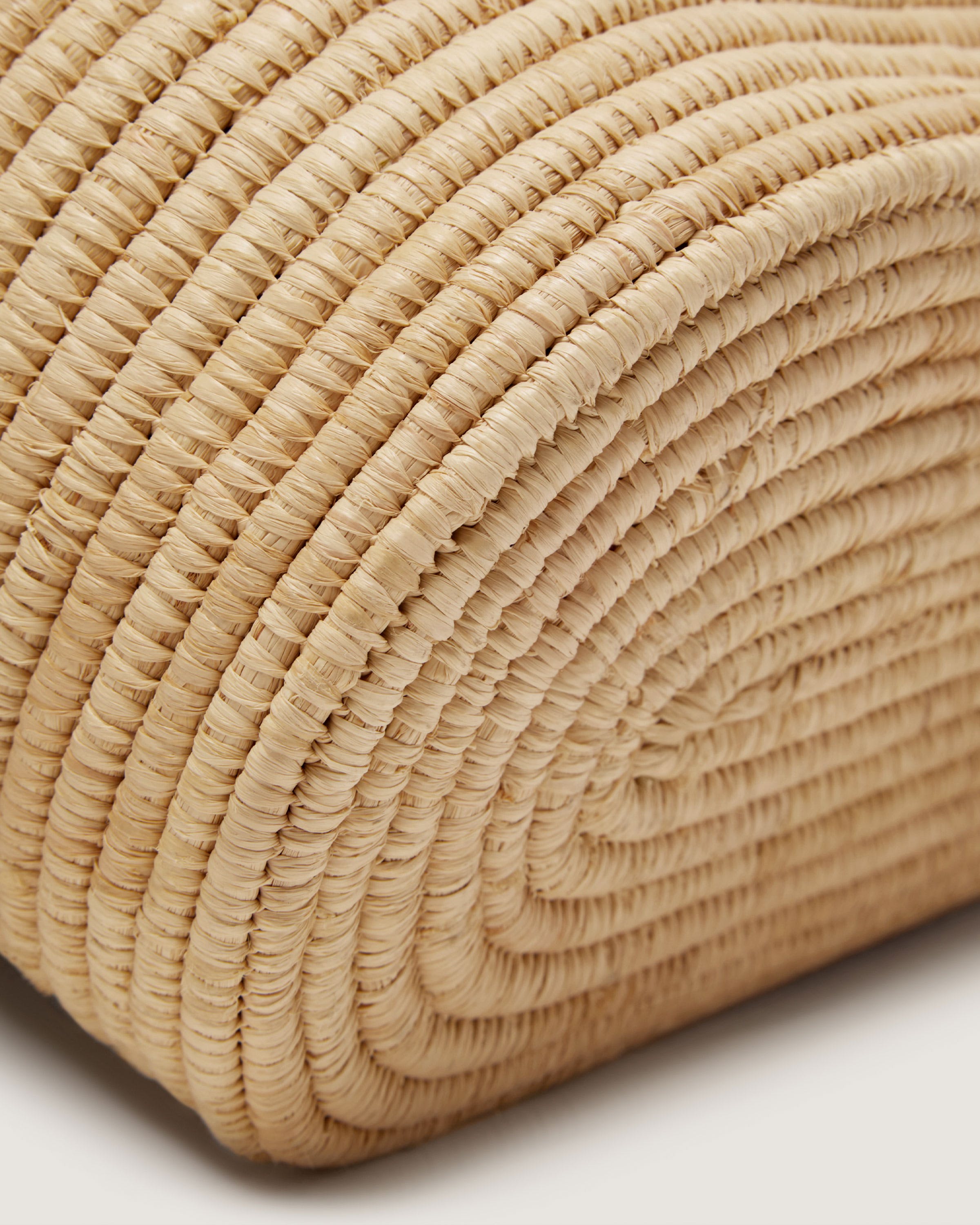 A close up of a woven bag on a white surface