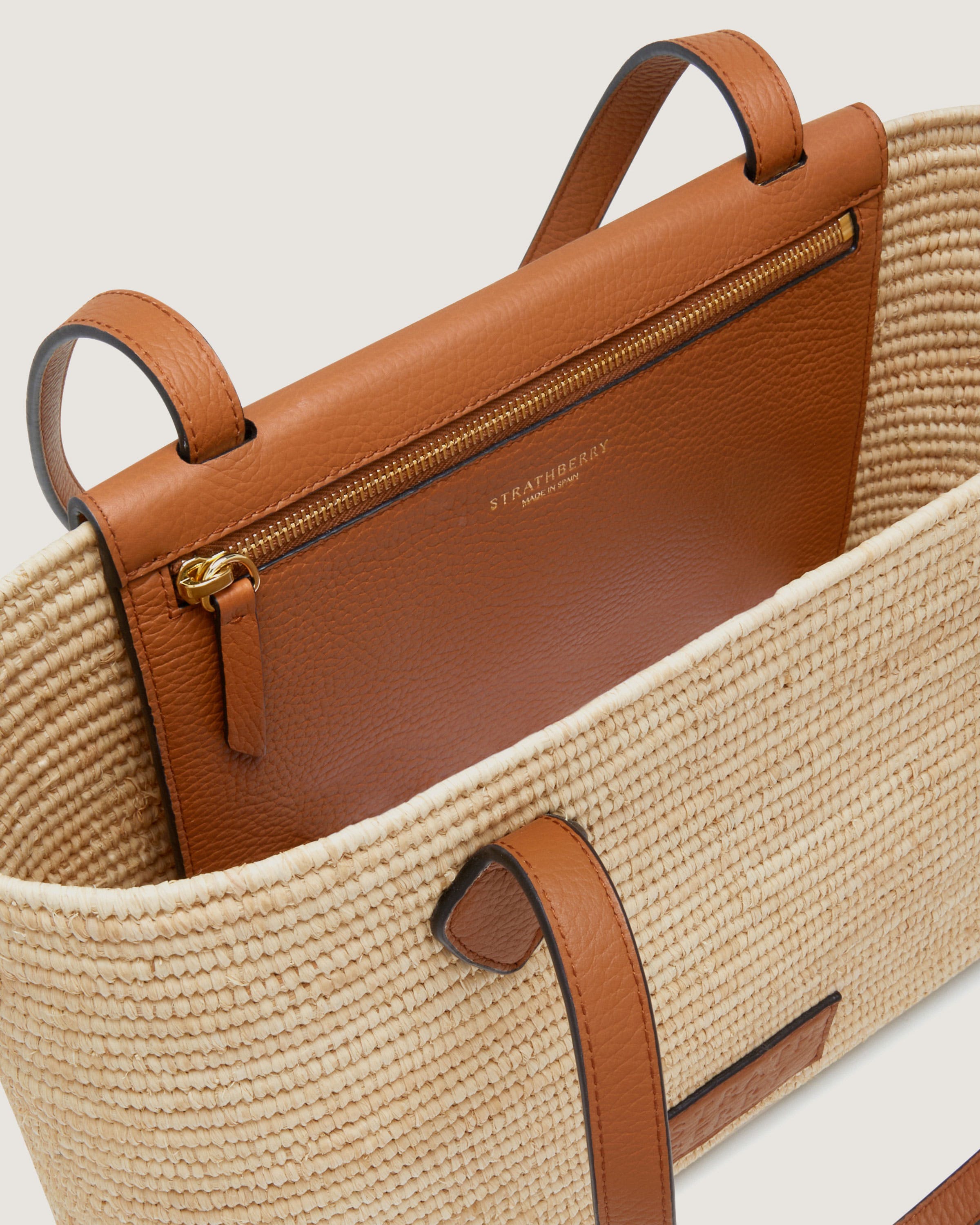 A brown and tan bag sitting on top of a white table