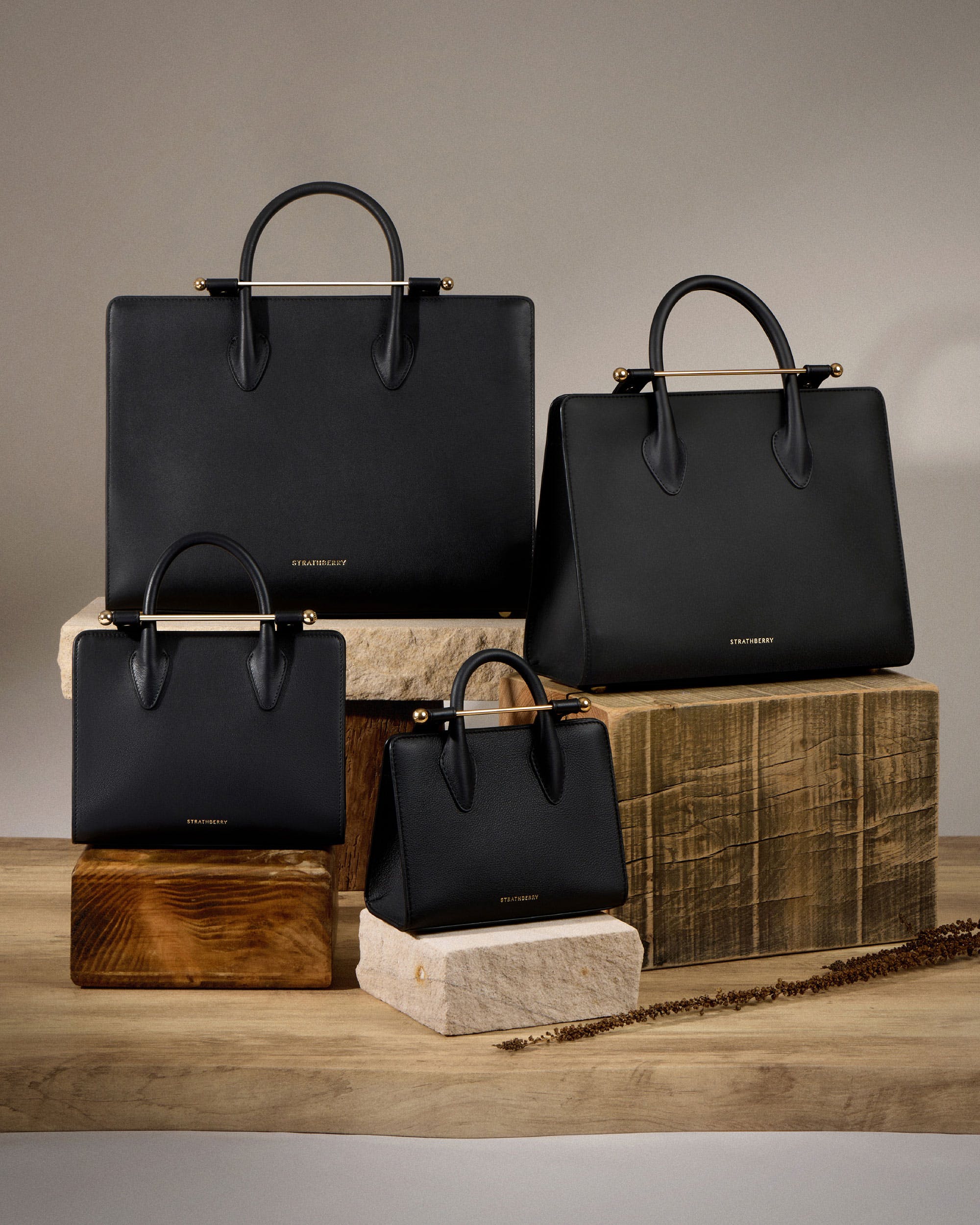 A group of black bags sitting on top of a wooden table