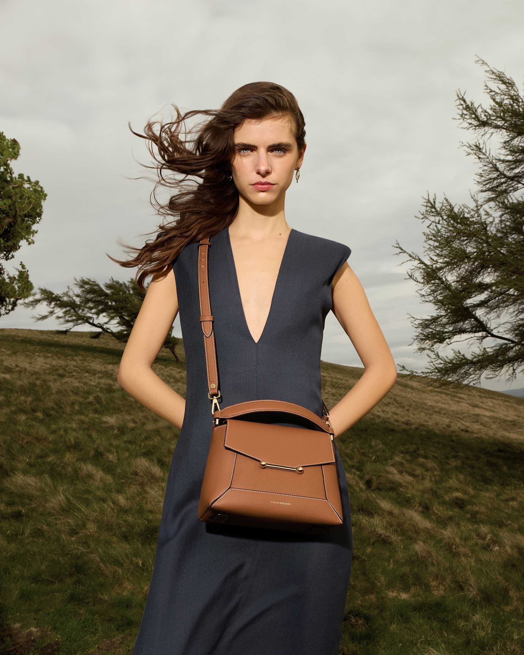 A woman in a dress holding a brown purse