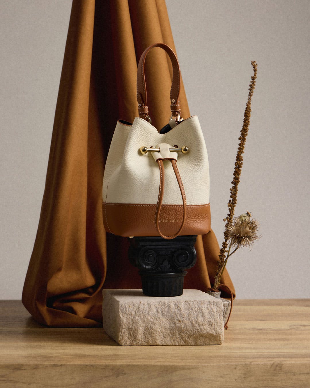 A purse sitting on top of a table next to a plant