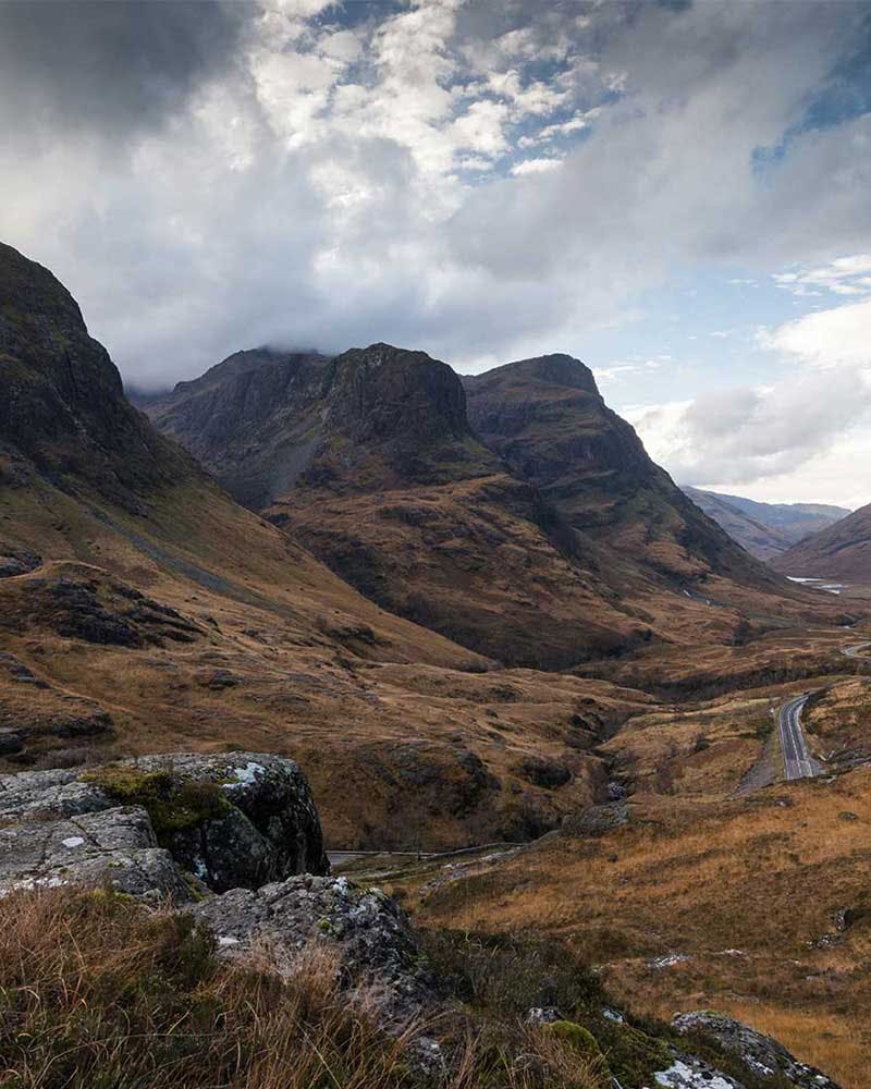 A scenic view of mountains and a road