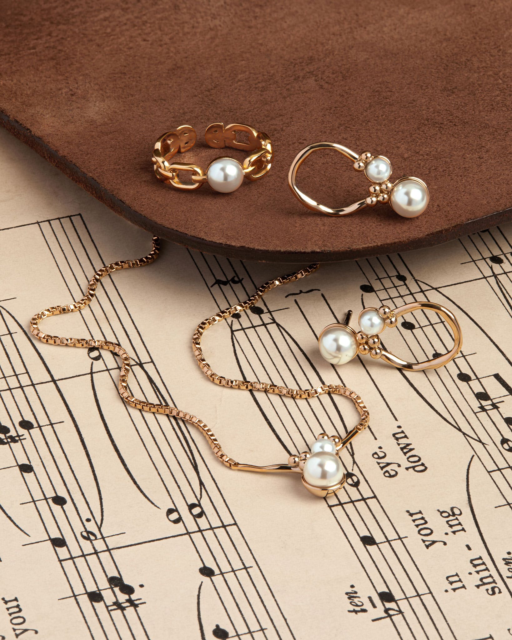 A pair of earrings sitting on top of a sheet of music