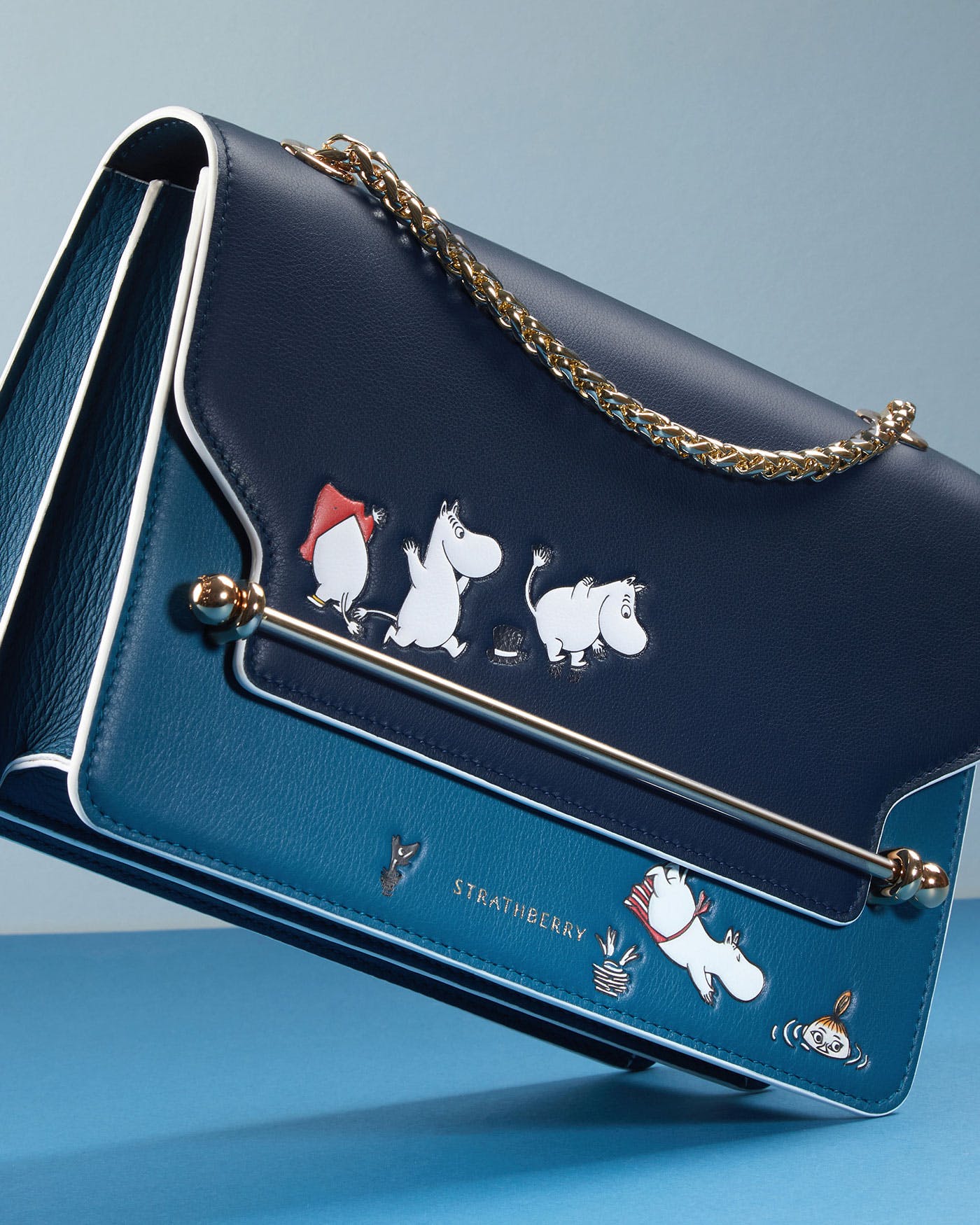 A blue purse with a picture of moomies on it