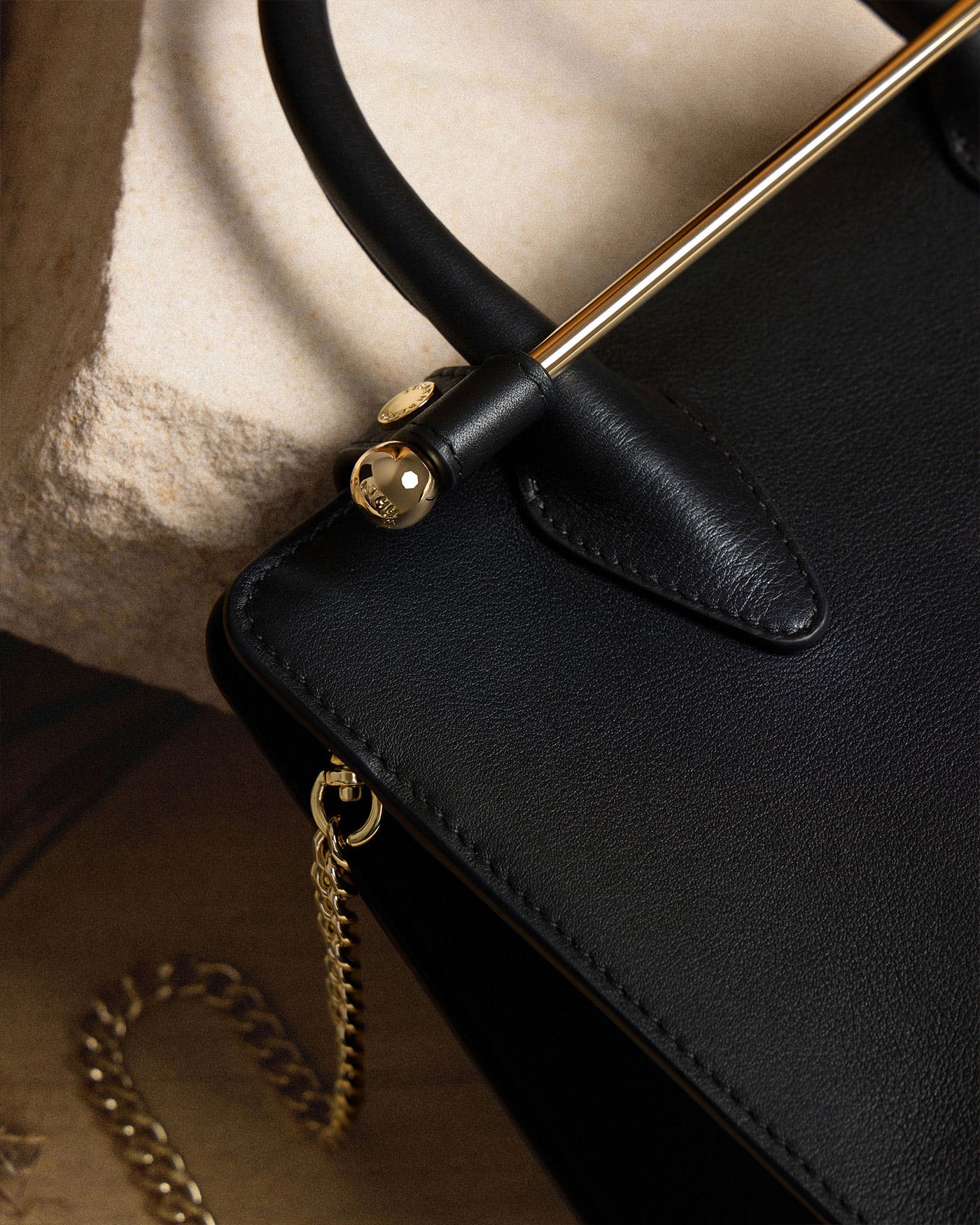 A close up of a black purse with a gold handle