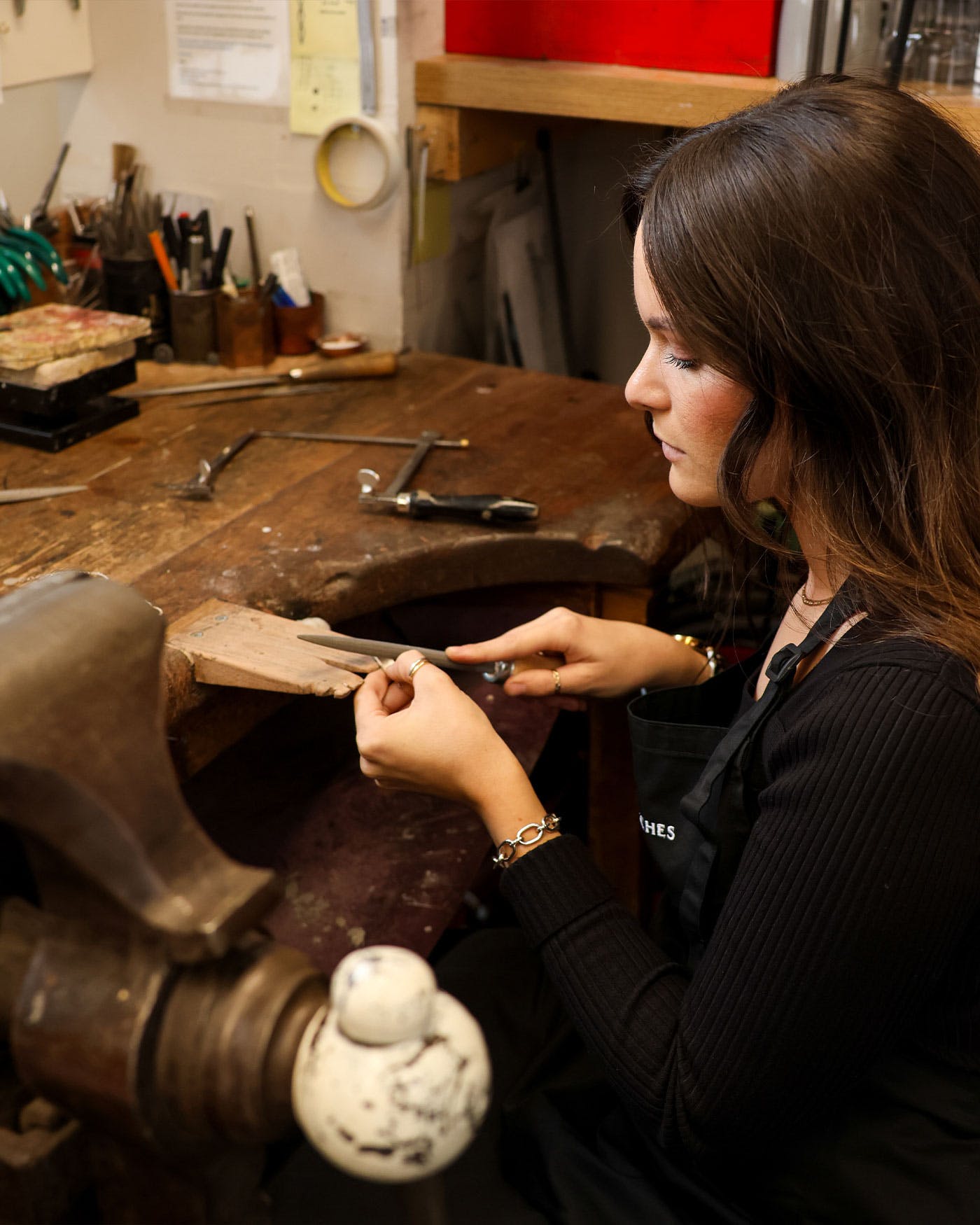 A woman is working on a piece of wood